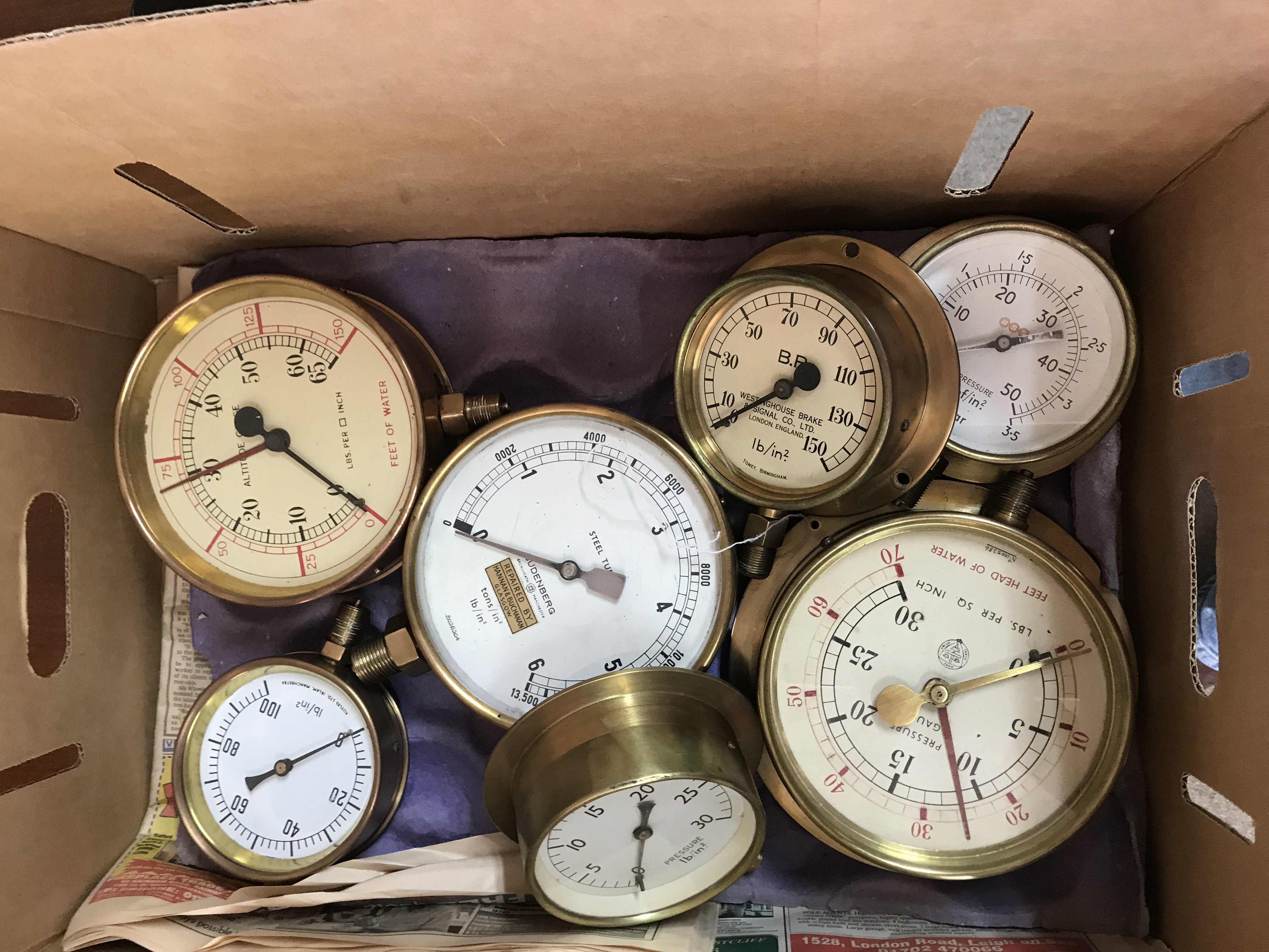 A box containing various pressure gauges.