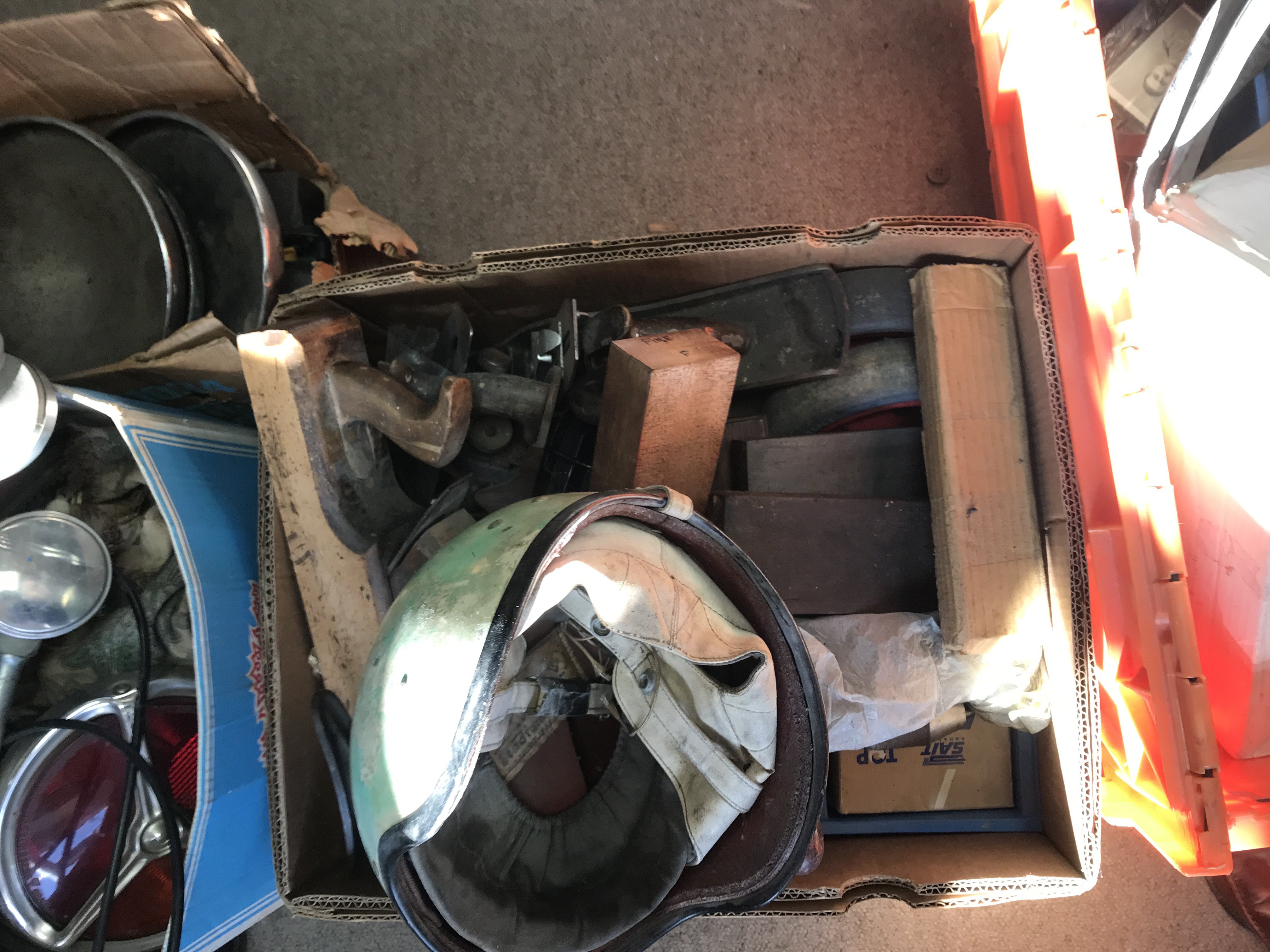 Five boxes containing moulding planes small oil tanks and car parts various and a vintage motorcycle helmet.