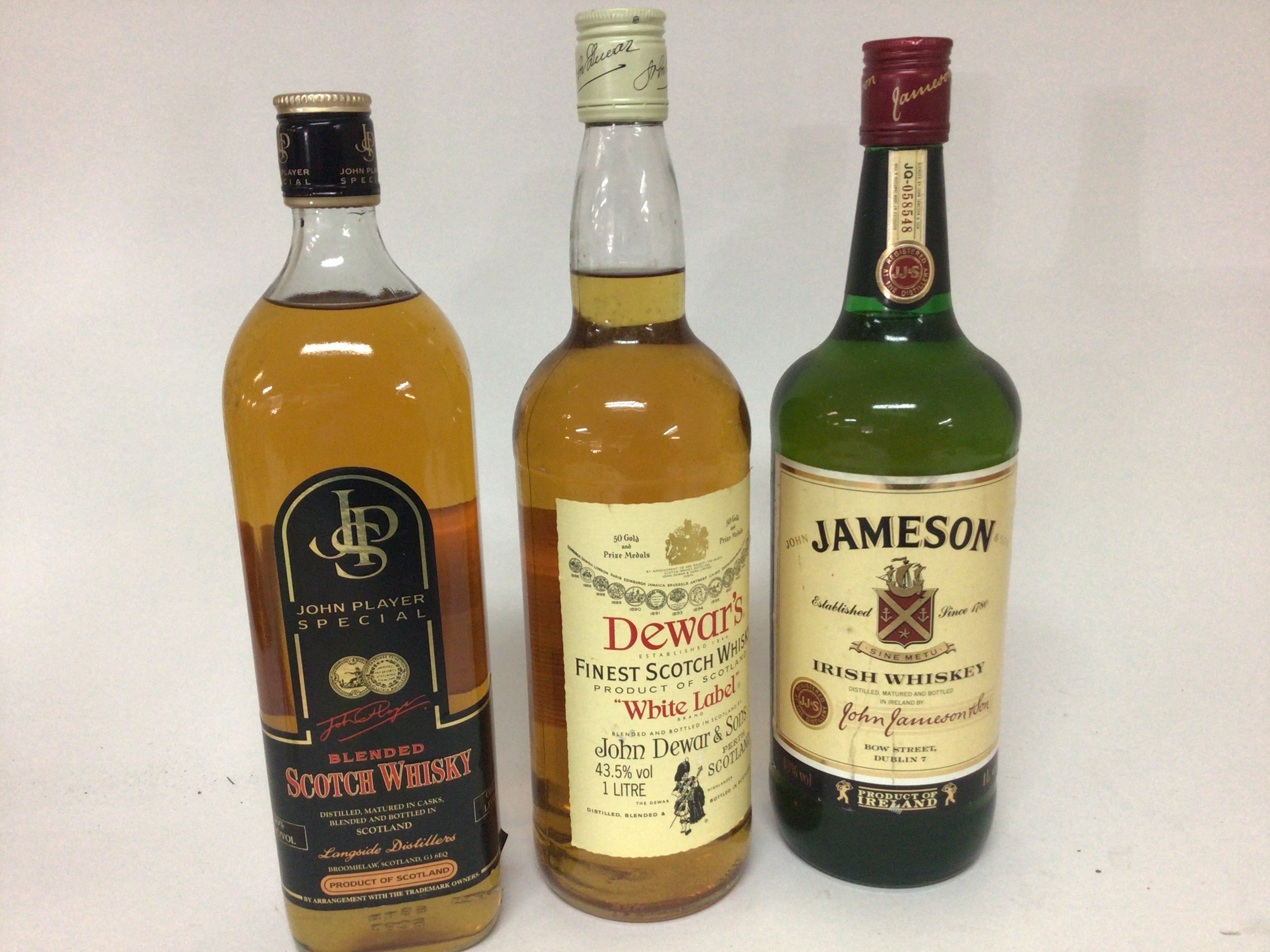 Three bottles of Whisky Irish Jameson JPS Scotch whisky and a bottle of Dewars all one litre bottles (3)