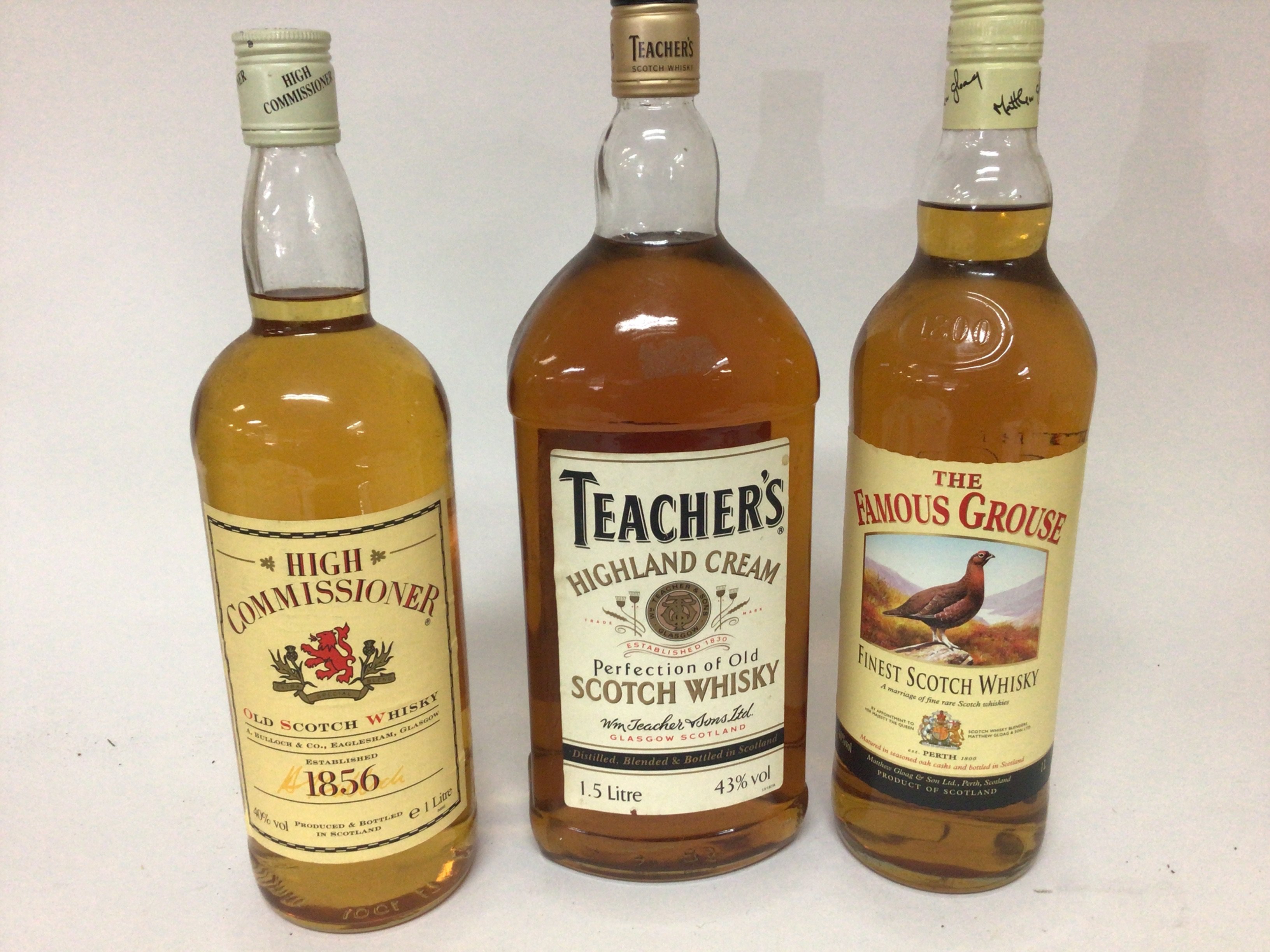 A 1.5 litre bottle of Teachers Scotch Whisky and bottle of High Commissioner and a bottle of The famous Grouse (3)