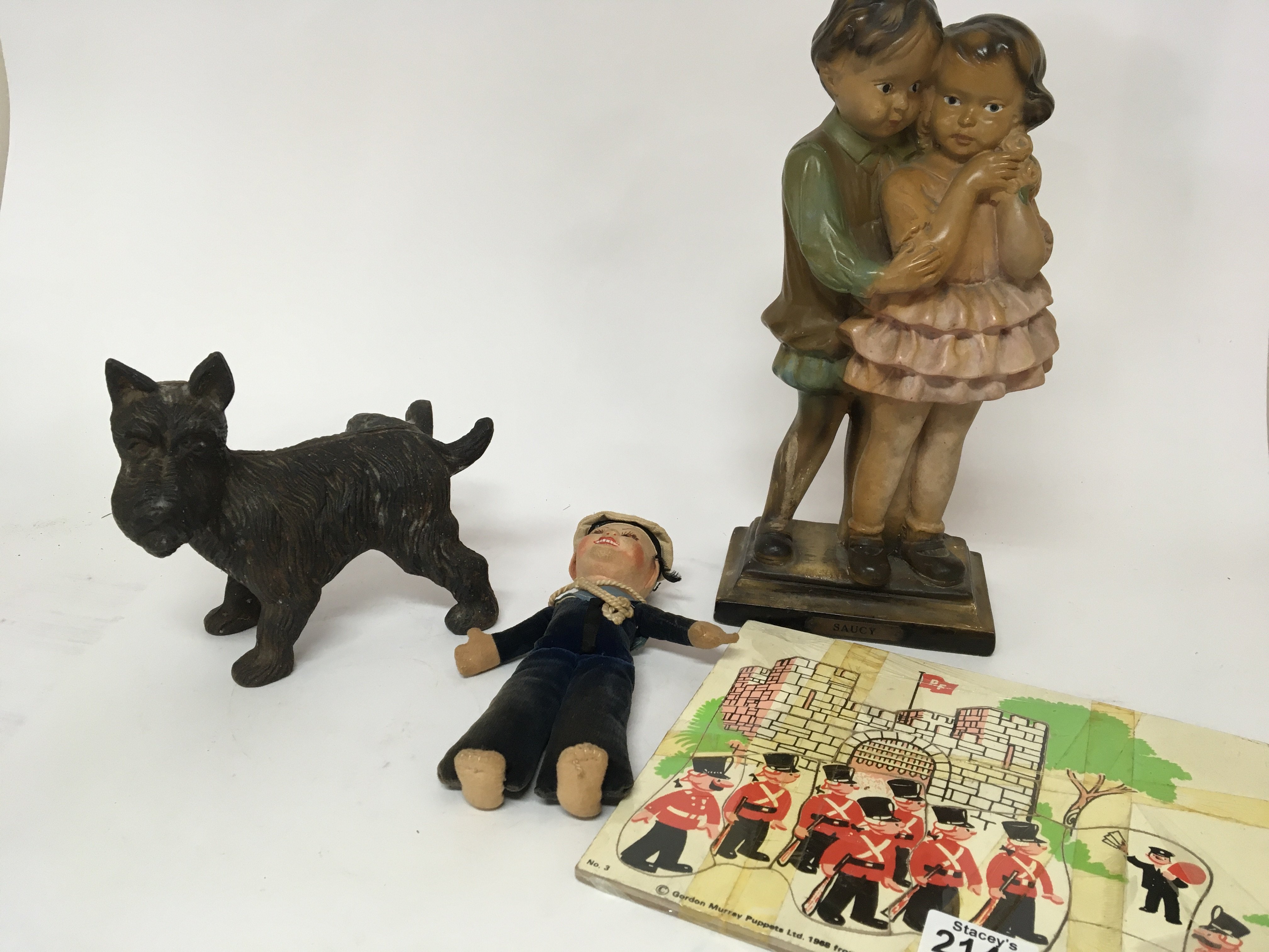 A Vintage Camberwick green puzzle a plaster Saucy figure a vintage sailor doll and a cast metal figure of a dog. (4)