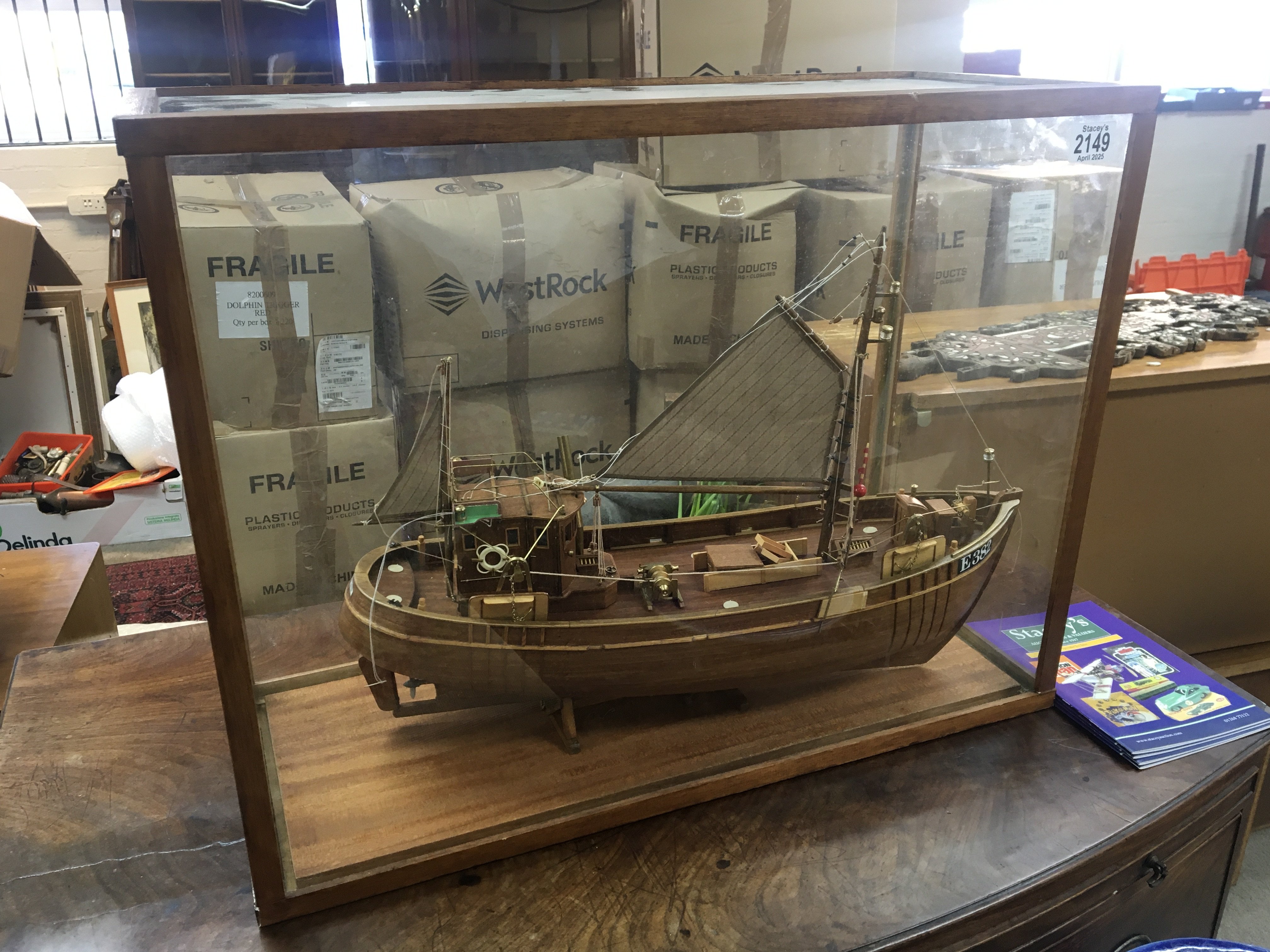 A scratch built detailed wood model of an off shore fishing boat in sail in a glass case. 65x50cm