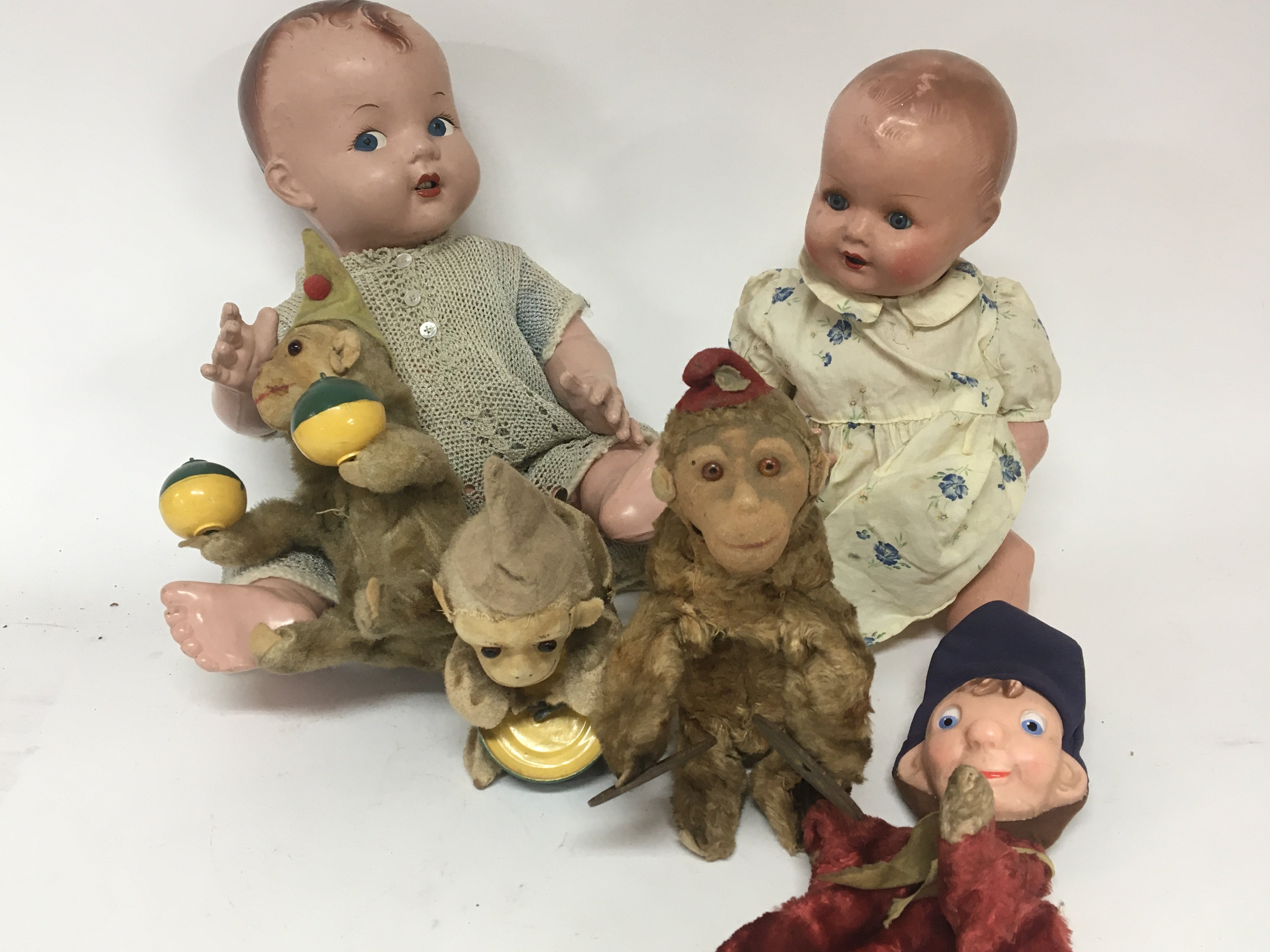 A collection of Vintage toys two composition dolls and a clockwork monkey band.