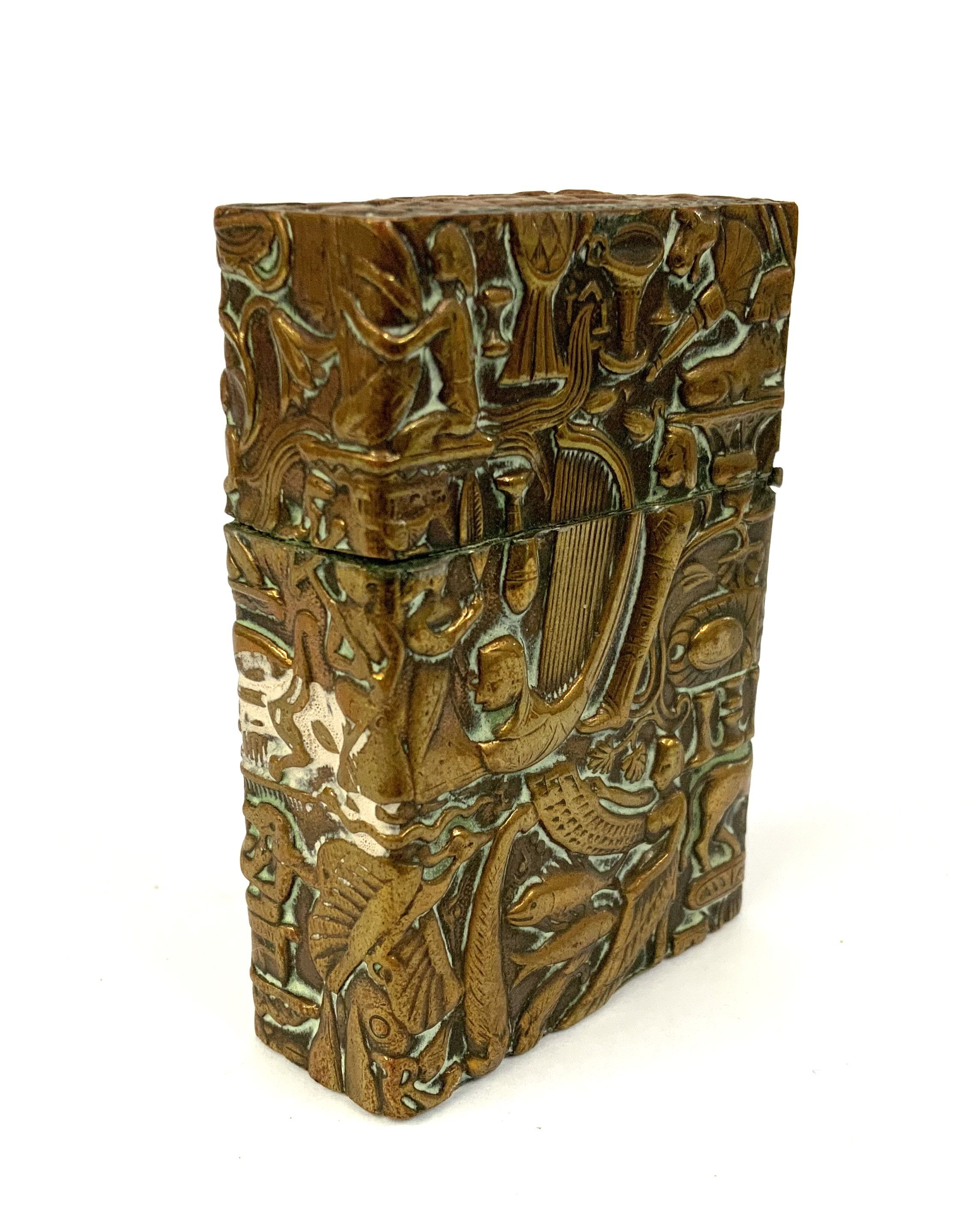 An antique C.1930s pressed brass cased lighter decorated with Egyptian symbols. 6cm. (A) NO RESERVE