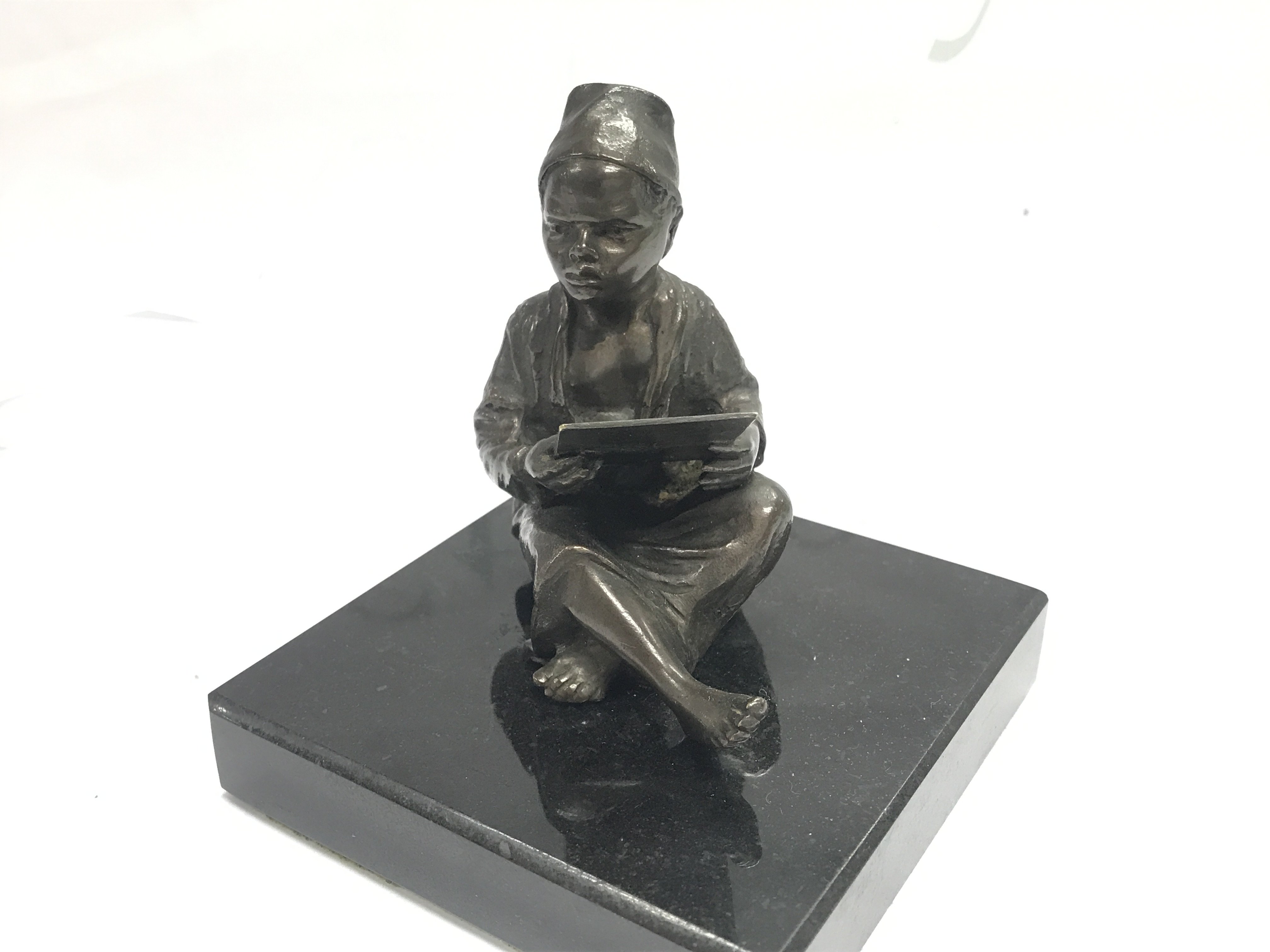 A bronze figure of an eastern boy on a marble plinth , 10cm tall. Postage cat B