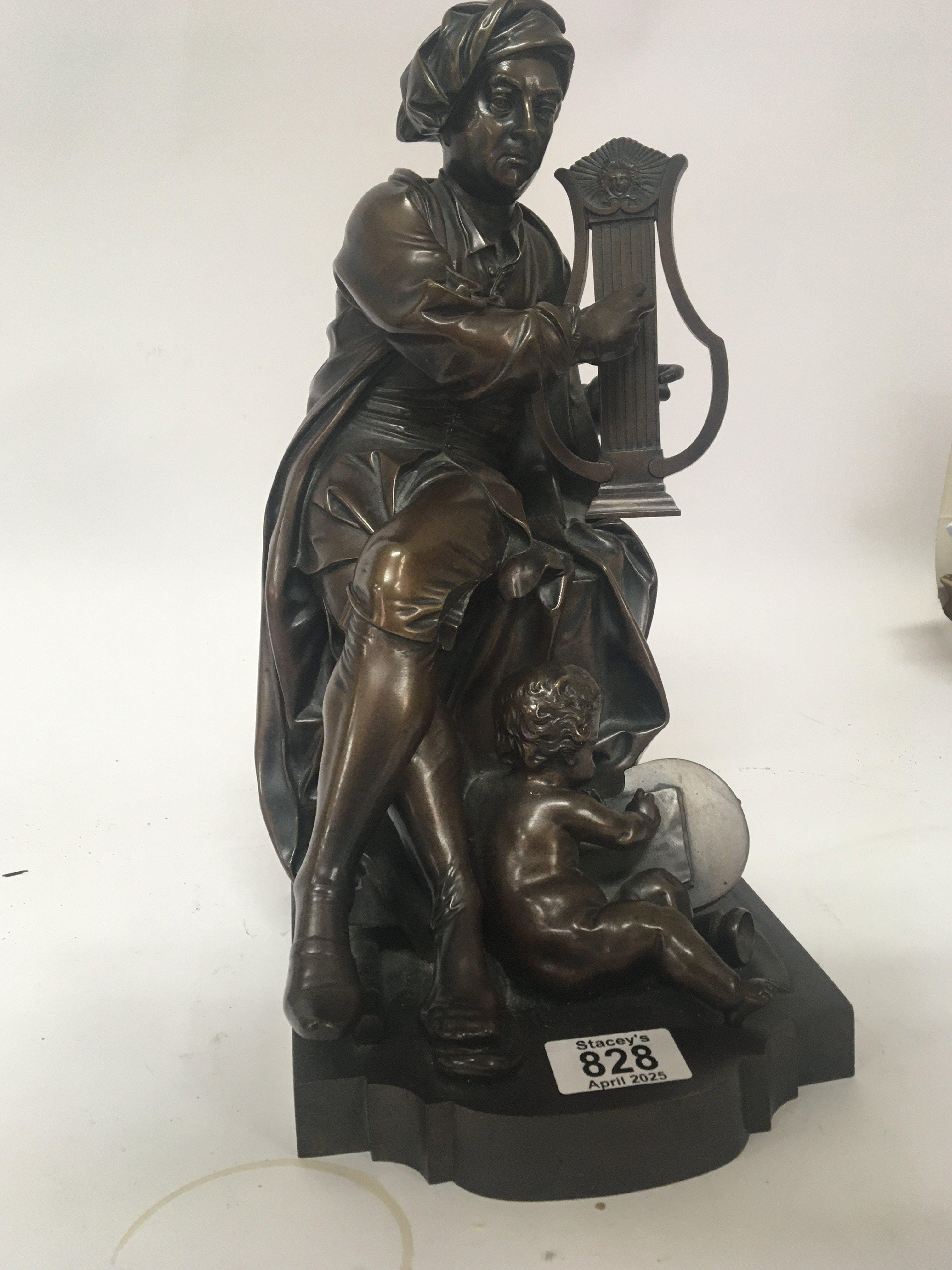A late 19th century Elkington &Co bronze figure group a Continental seated figure playing a harp with a small putti at foot scribing a tablet. Marks to the underside of the base. Hight 37cm