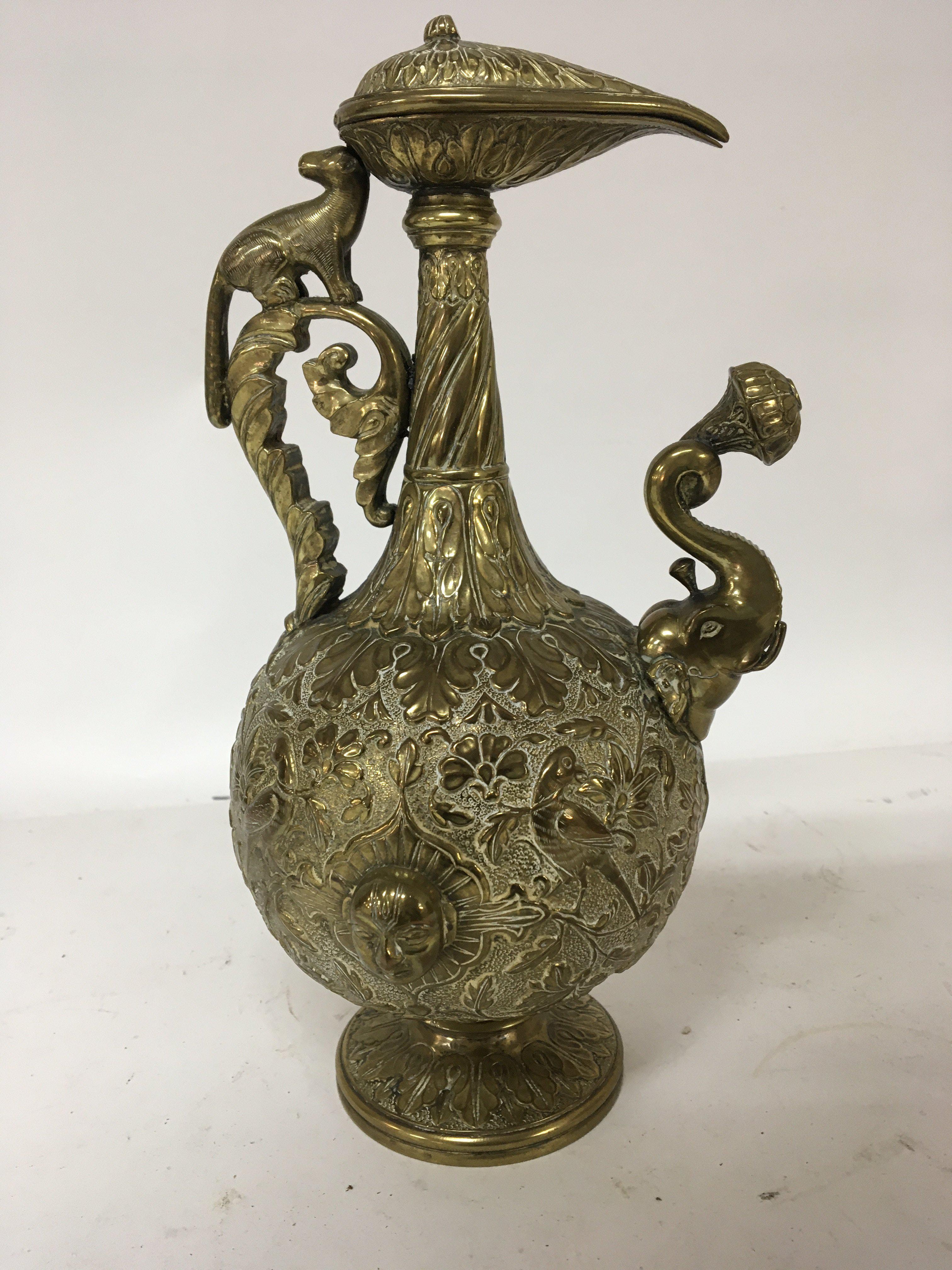 A Quality and interesting 19th century wine vessel with profuse decoration with birds and foliage raised heads a scroll handle and elephant shaped spout. Height 26cm.