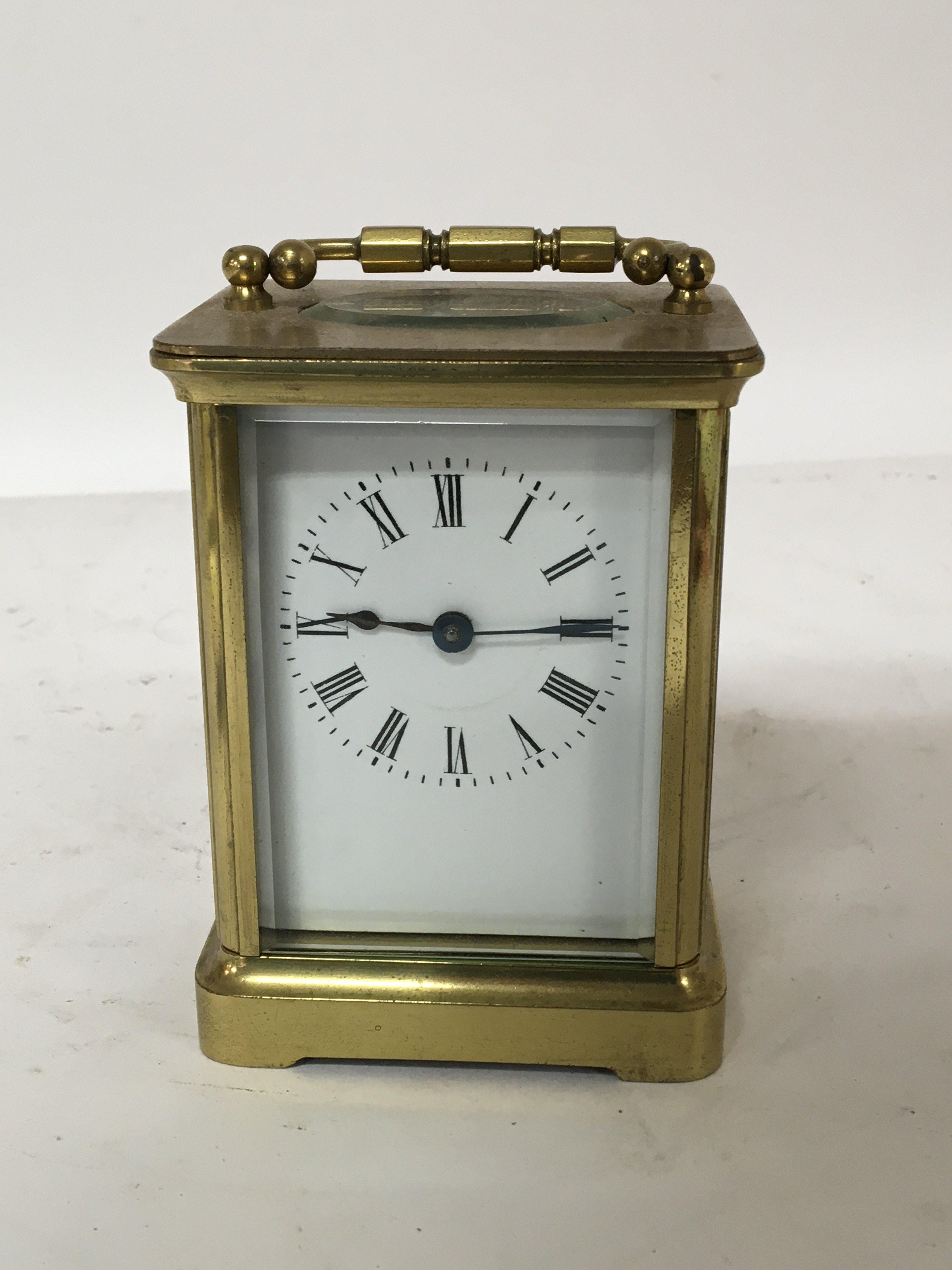 A brass cased carriage clock enamel dial seen working. Height 11cm