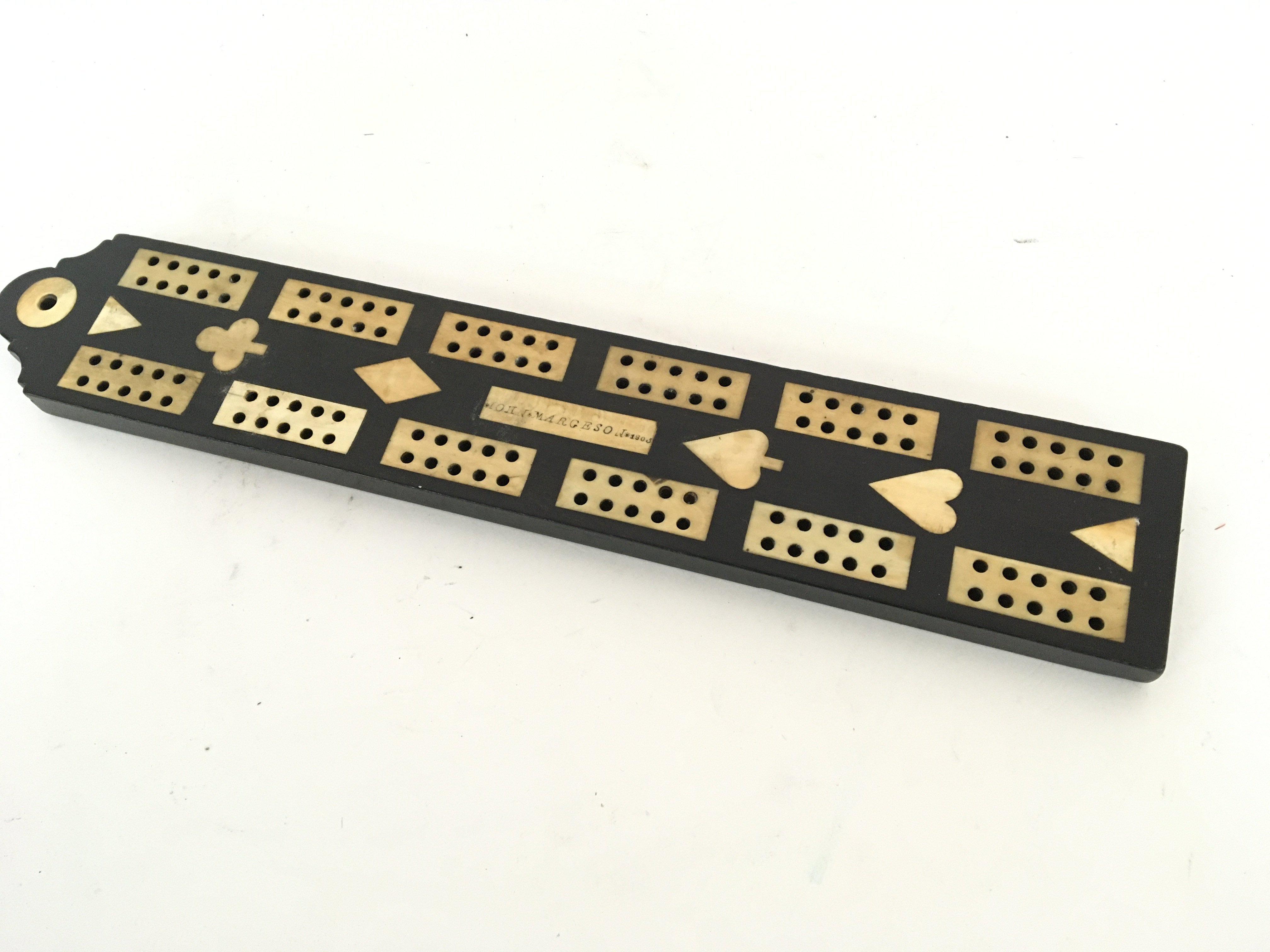 A 19th century George III Prisoner of war ebony cribbage board with bone inlaid rectangular pegs. Length 33cm.