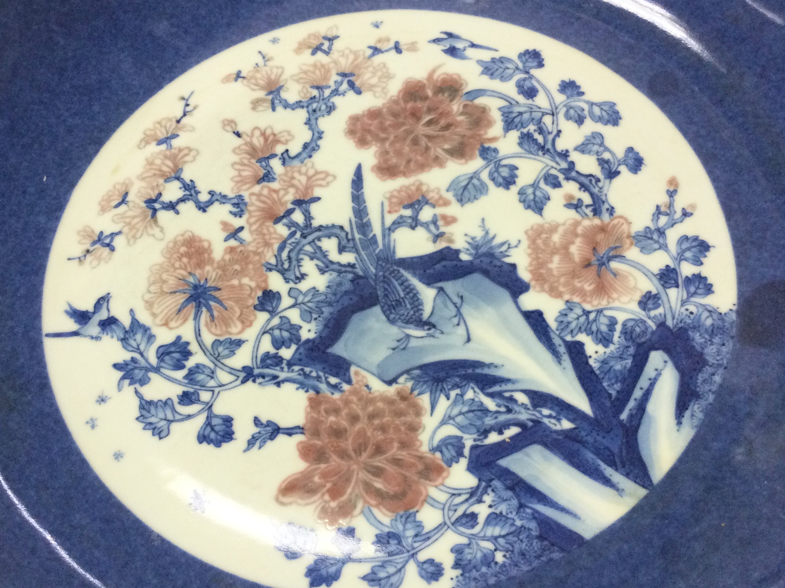 A Chinese blue and white and copper red floral porcelain charger, 30cm wide. This lot cannot be posted