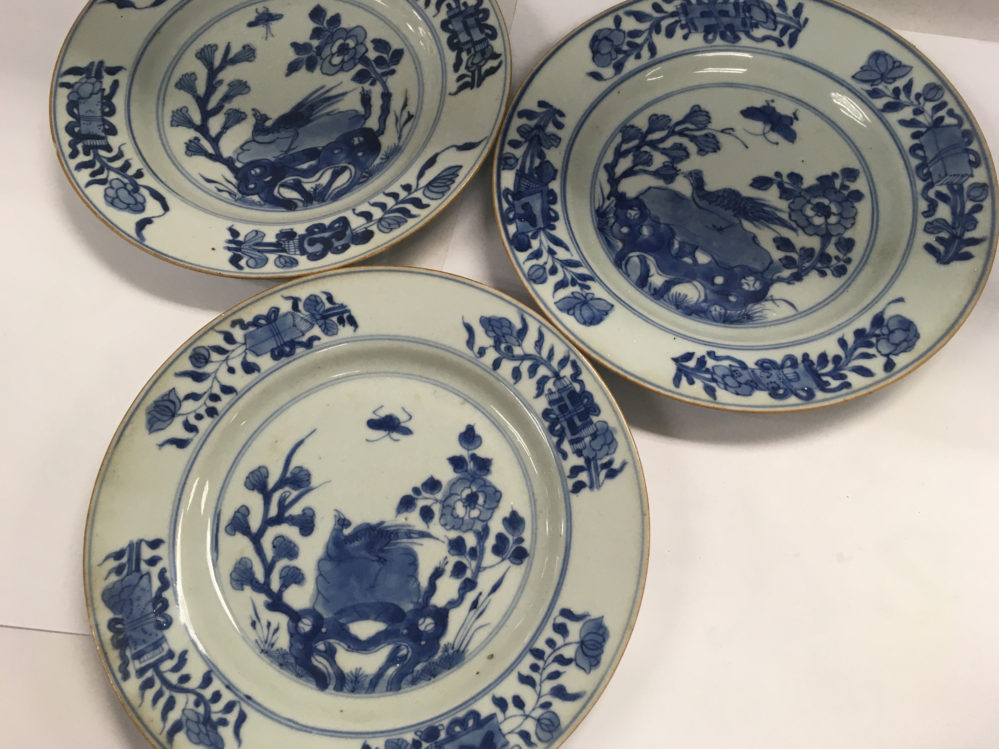 Three Early 19 th Chinese blue and white plates decorated with birds flowers and foliage.