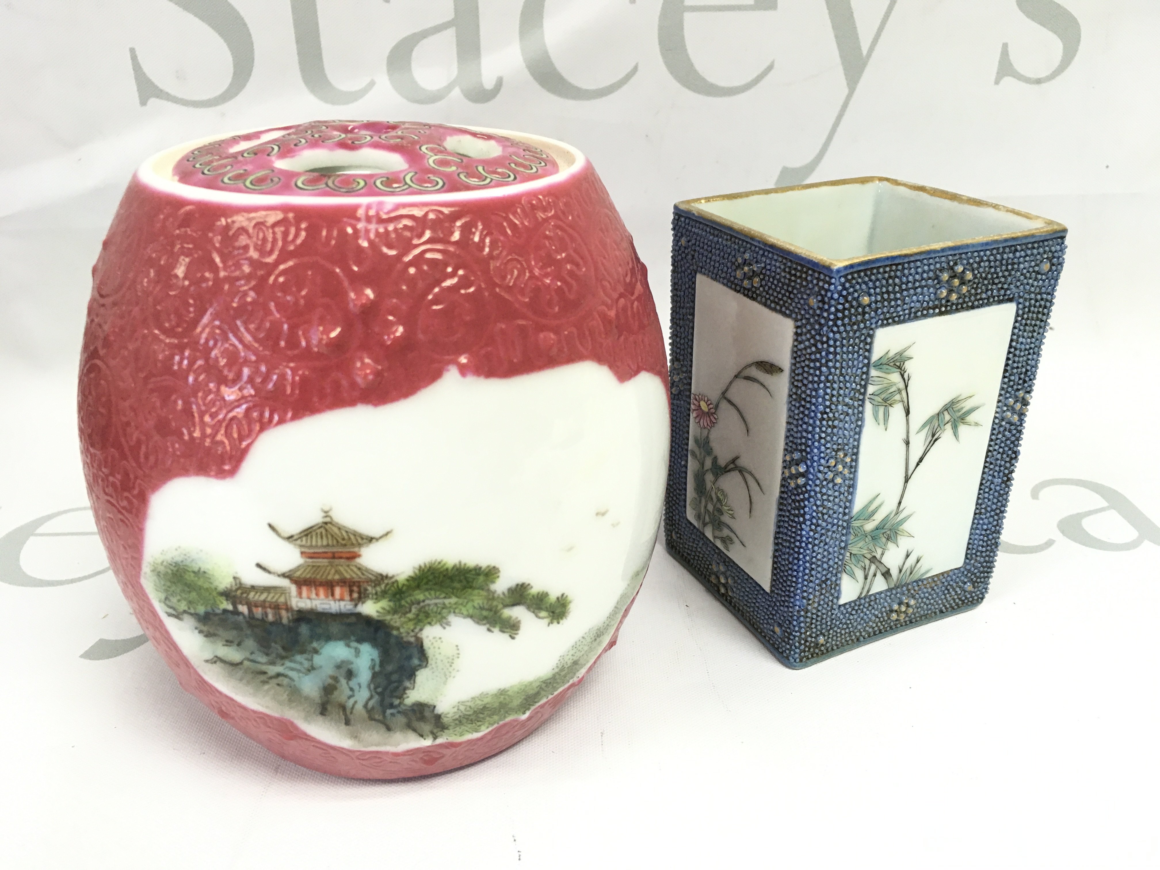 A Chinese Famille Rose brush pot with painted floral design panels ,surrounded by a light blue chicken skin ground and a red ginger jar decorated with hand painted landscape scenes . This lot cannot be posted