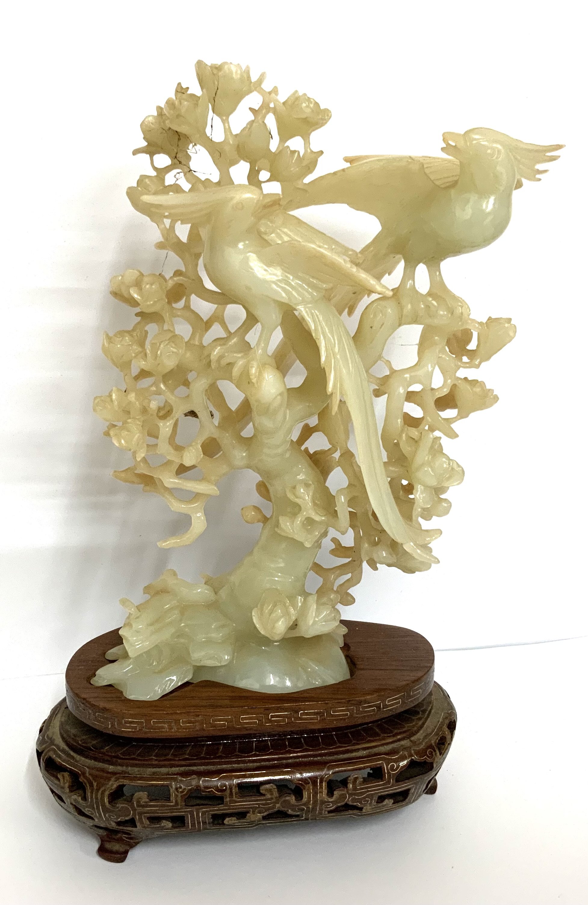 A Chinese bowenite carving of a parrots perched on a tree 20th century, with fitted wood stand, 18cm high (23cm on stand)