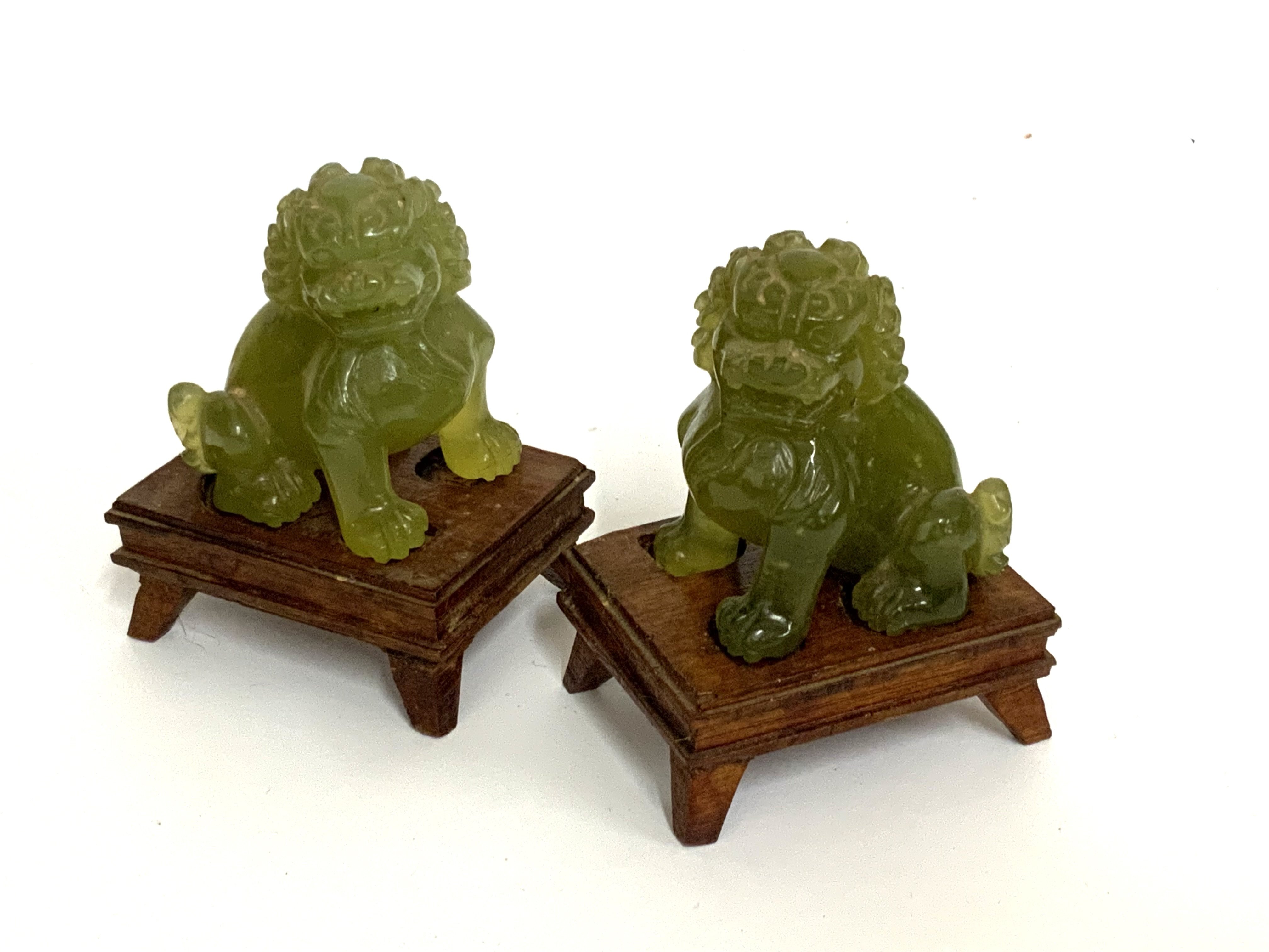 A small pair of carved jade lion dogs mounted pin carved wooden bases. (B)
