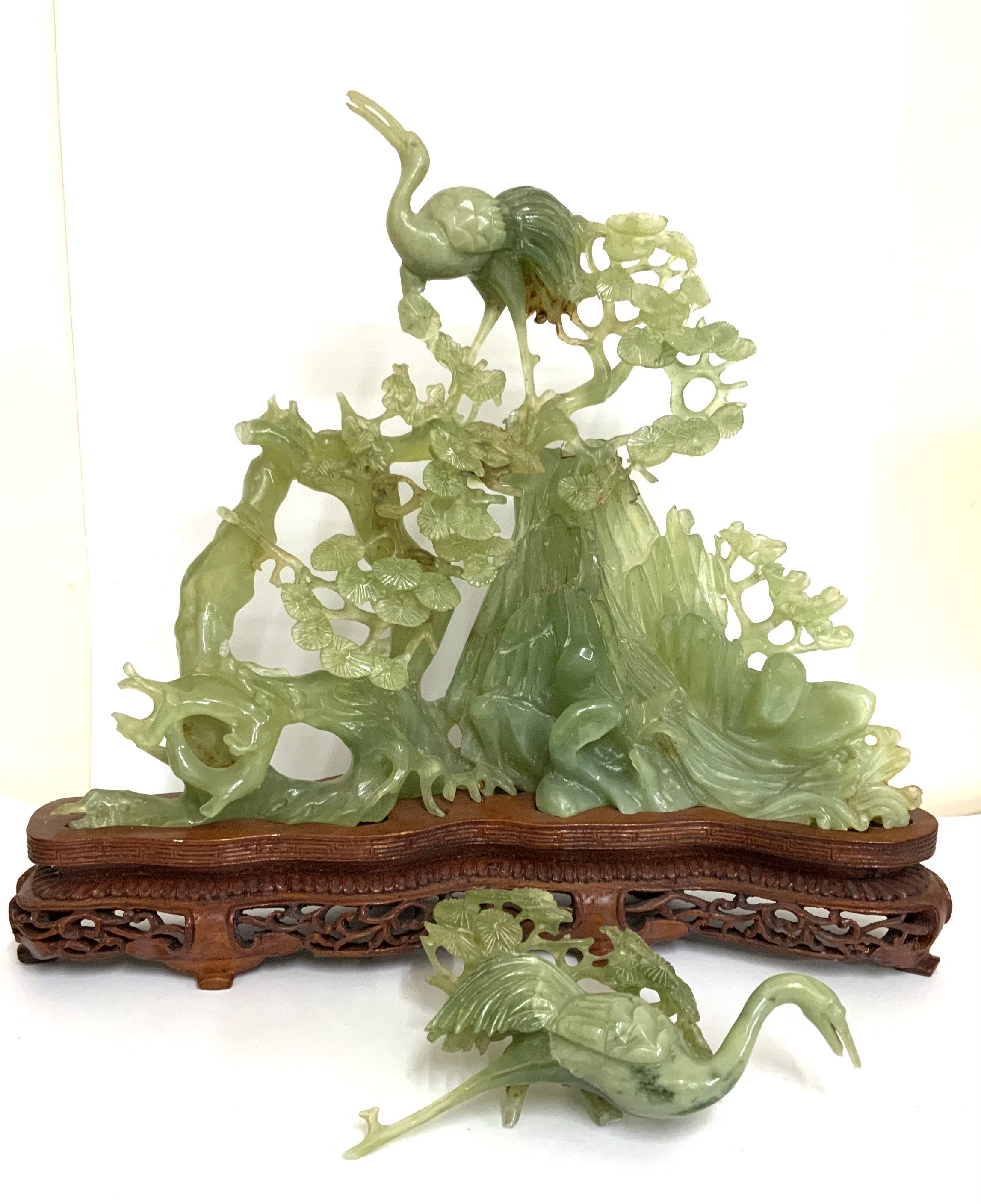 A carved Jadeite group figure depicting cranes in a mountain landscape. (A/F) 26.5cm x 29cm.