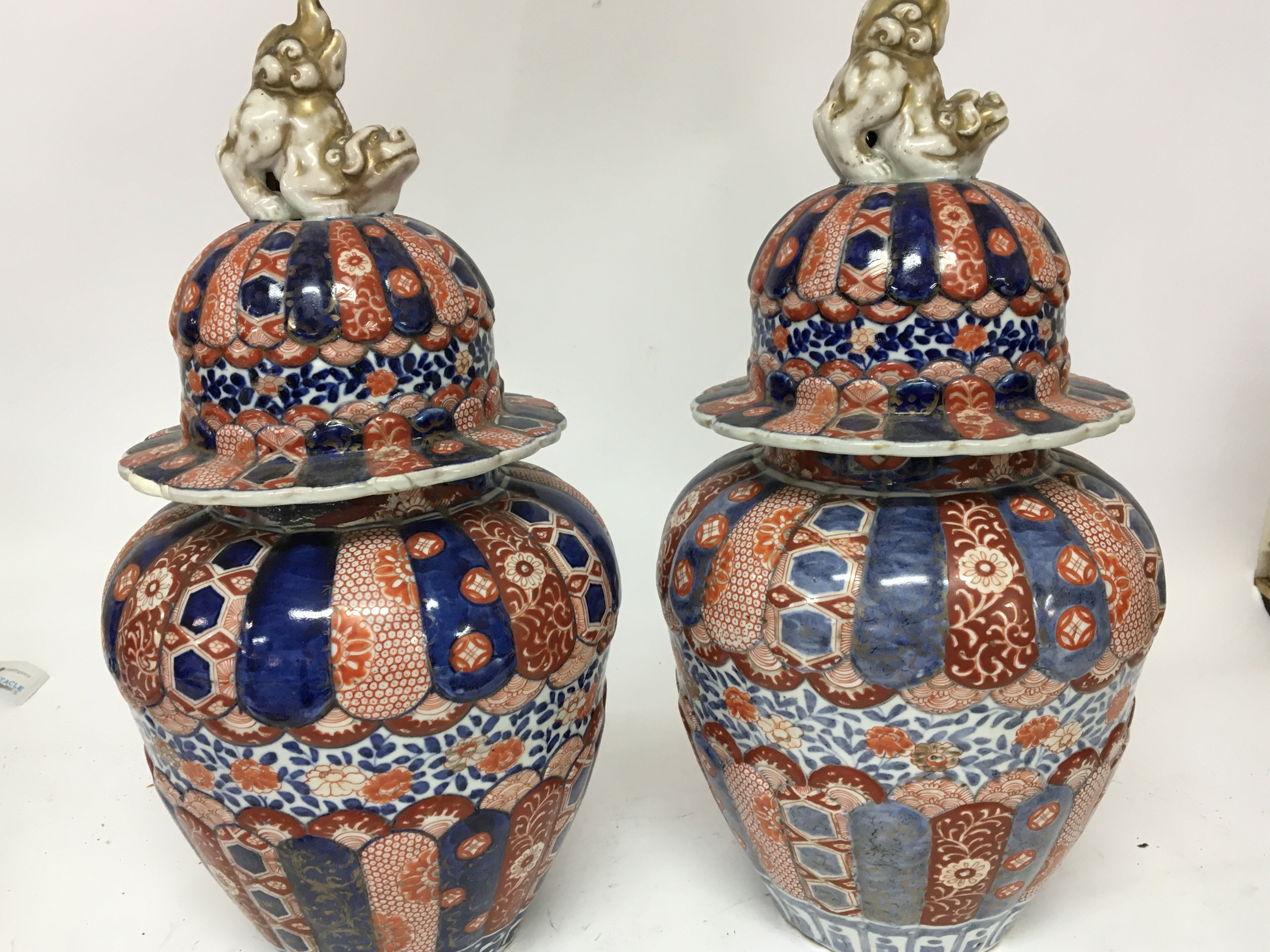A pair of Japanese Imari late 19th century vases with covers surmounted with dogs of foo. Some restoration height 42cm