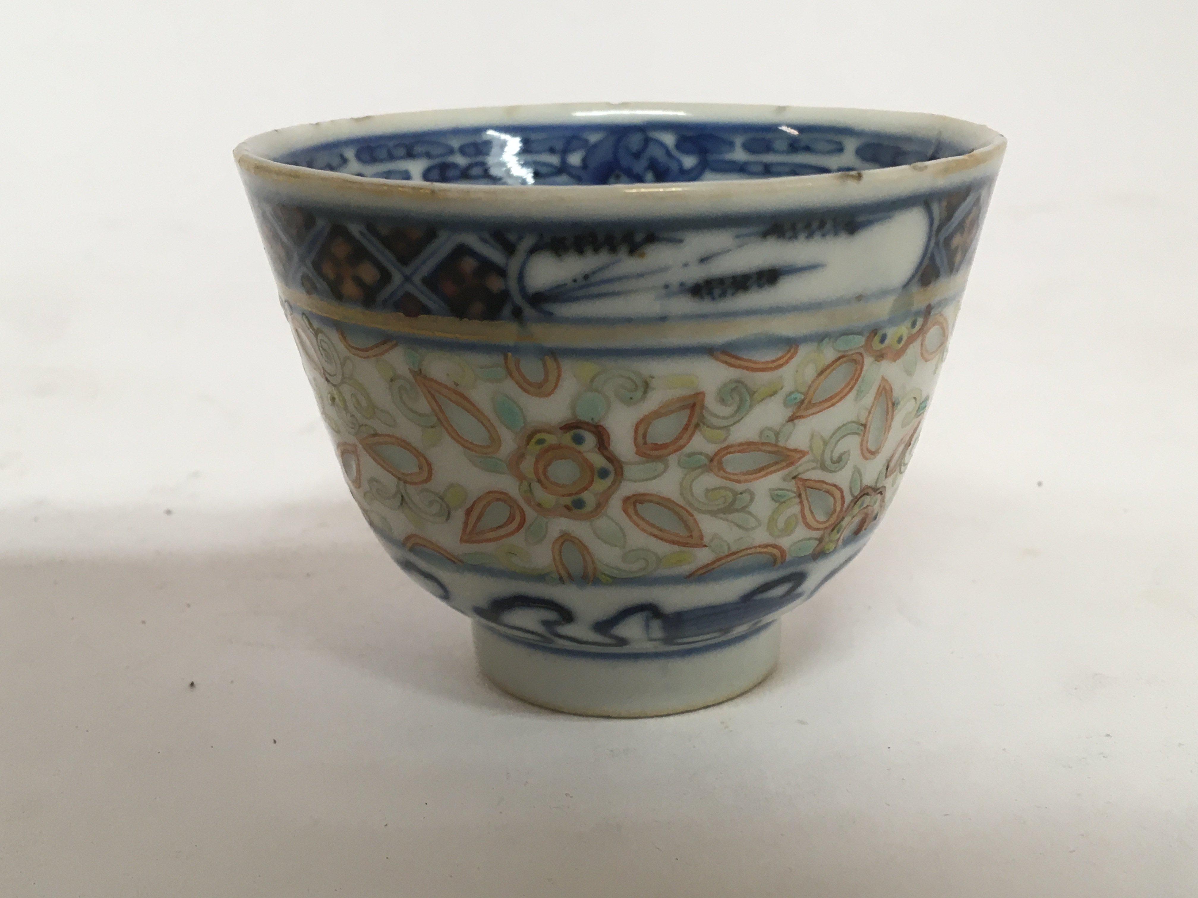 An 18th Century Chinese export porcelain tea bowl with translucent sides patterned and caricature marks to the base.