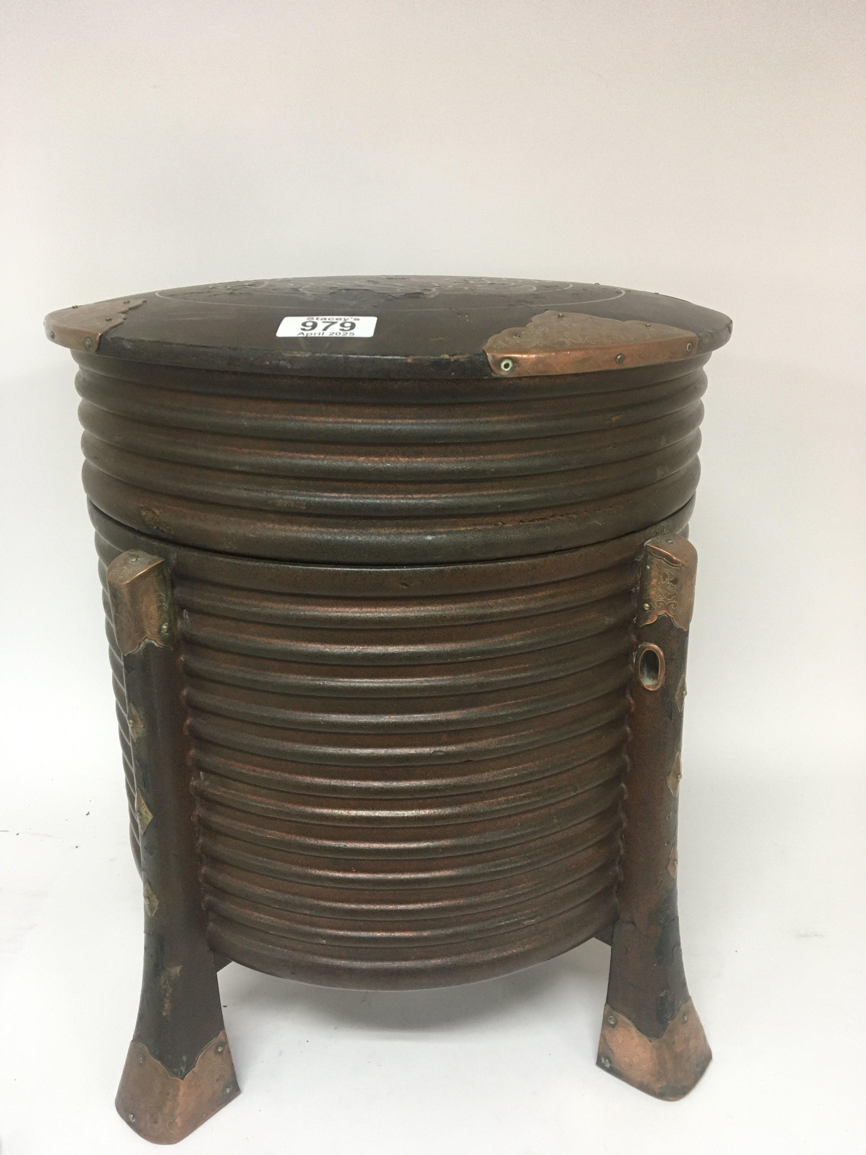 A large Oriental lacquer vessel of circular shape with ornate copper mounts. Height 43cm