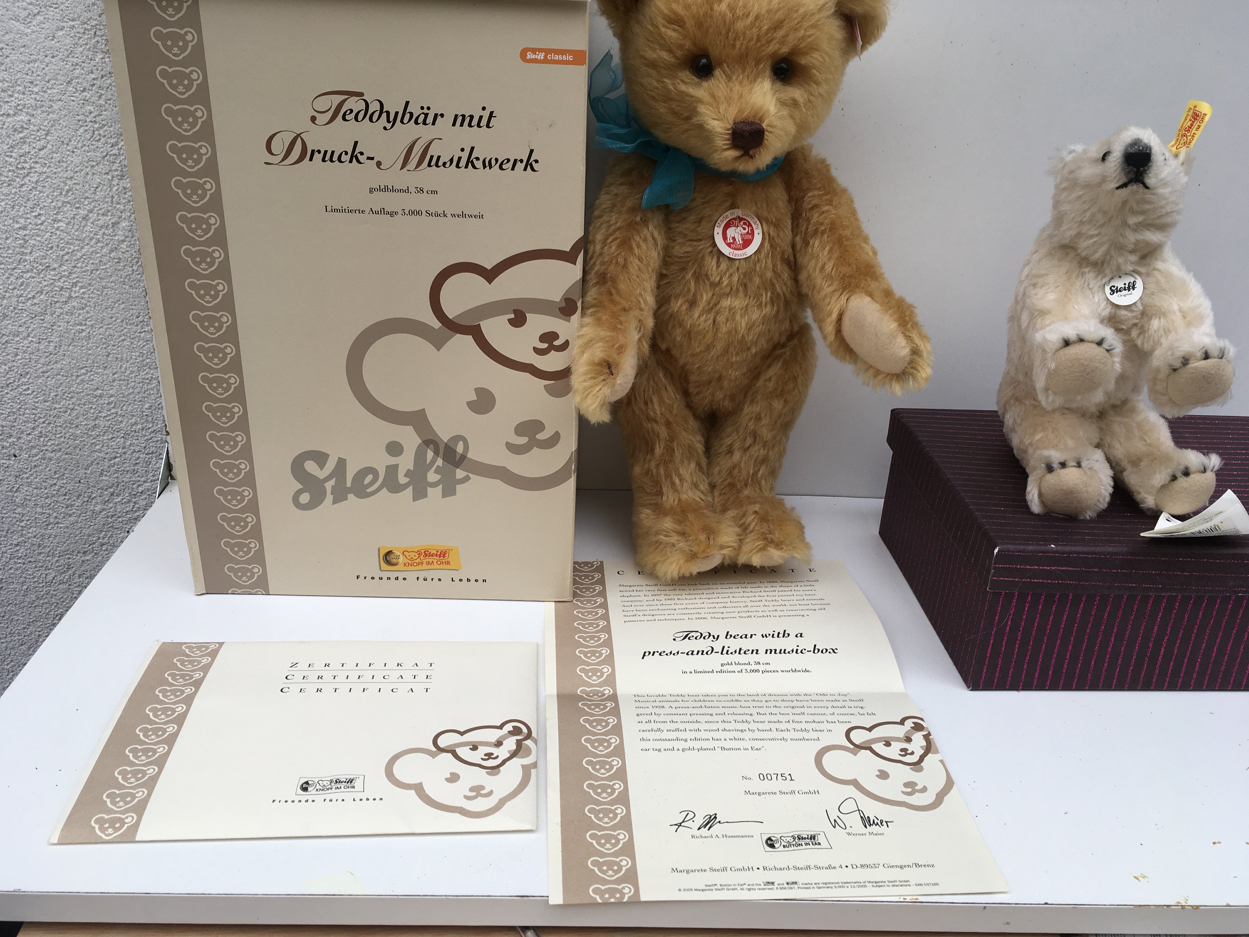 Two boxed Steiff toys featuring a gold blond Teddy bear 38cms with a press me music box and a white Polar bear. The teddy bear is no.751 of 3000. Certicate included. No reserve. (2)