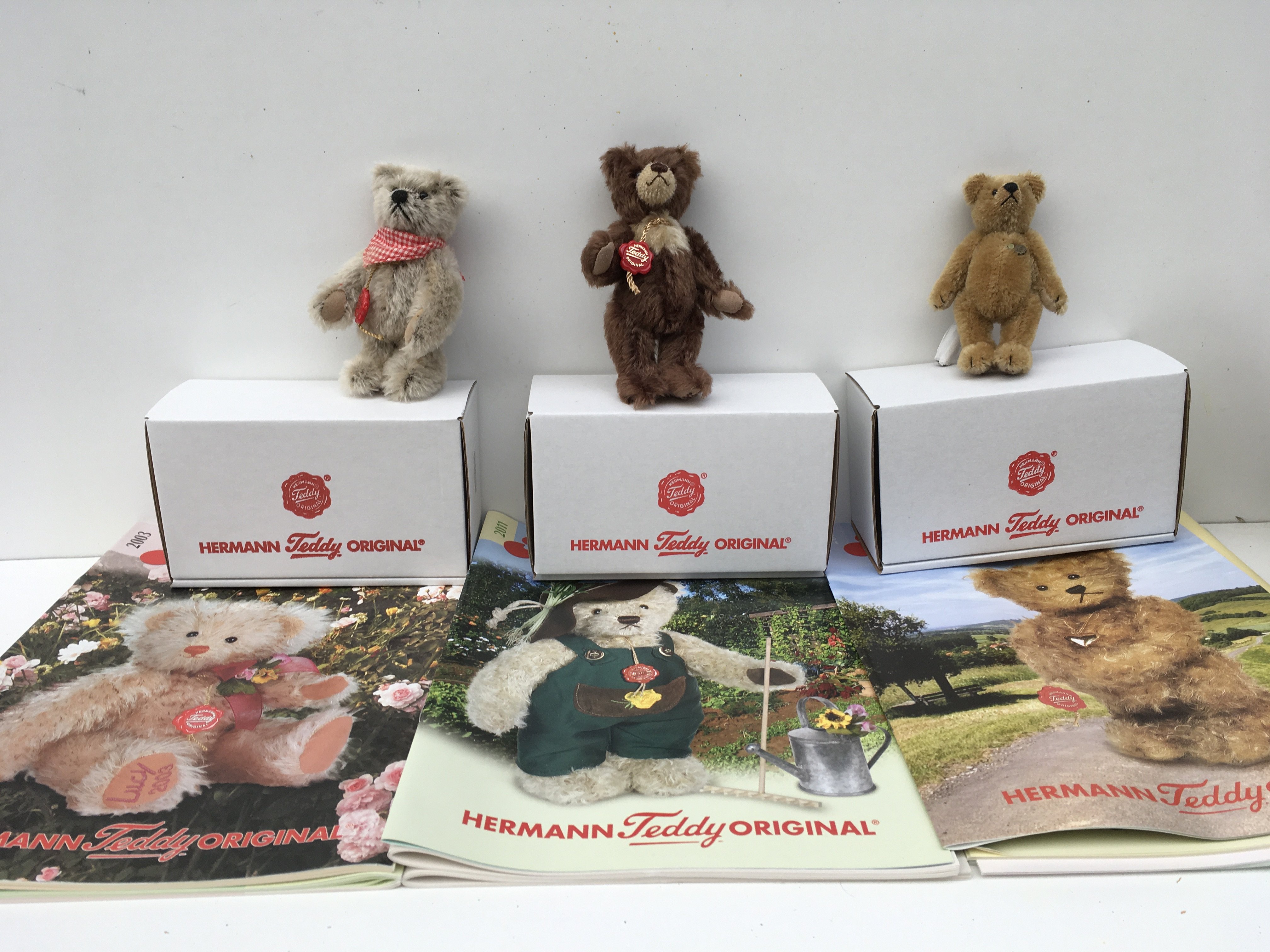Three boxed minature Herman teddy bears given as a gift to club members. Includes 2003 a 12cms light brown ..2004 11cms golden brown..2011 13cms dark brown with light chest. No reserve