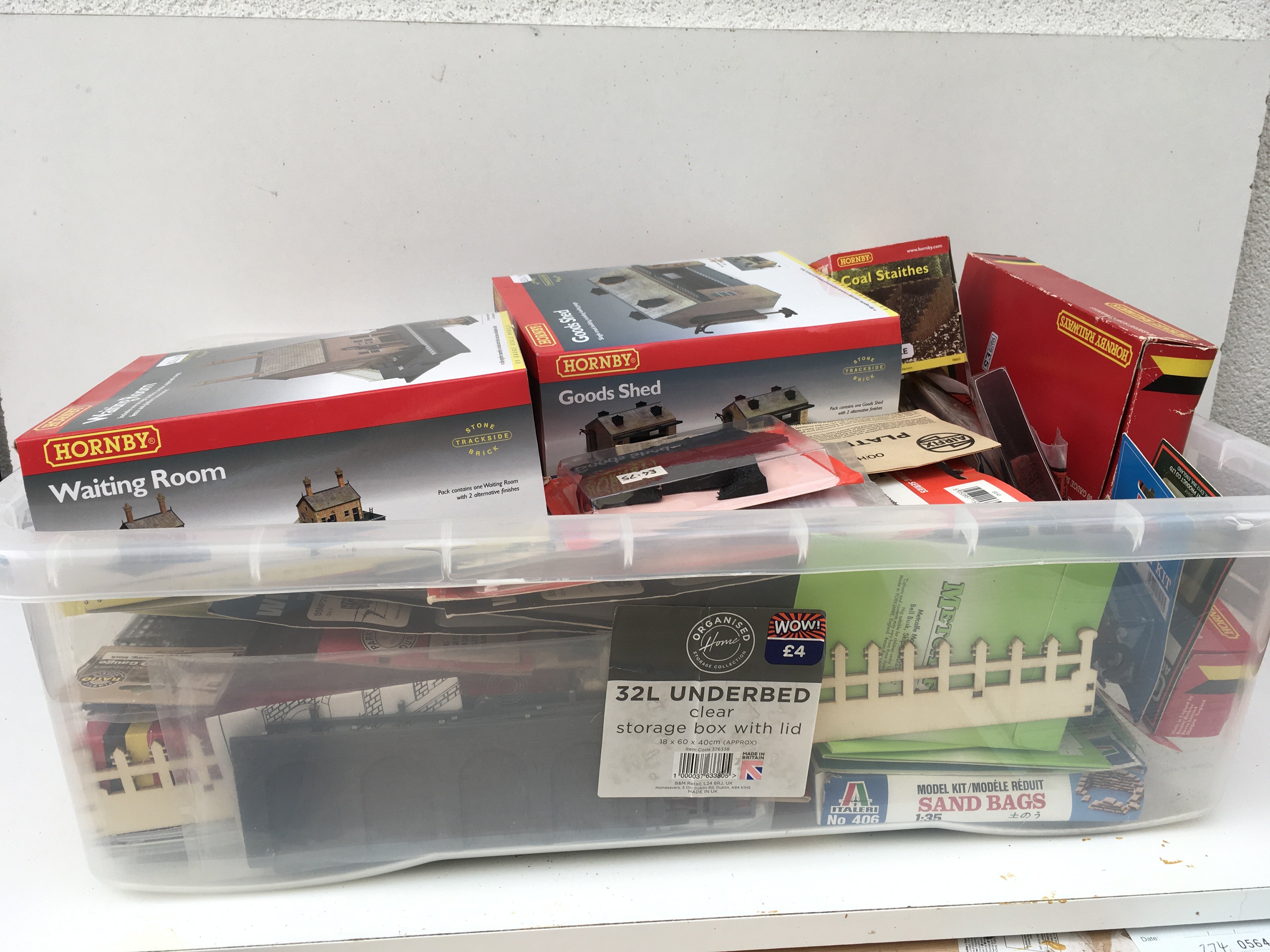 A box containing a large selection of model railway accessories mostly new and unused. Includes buildings..scenery..vehicles etc. multiple manufacturers including Hornby..Metcalfe..Ratio plus others. No reserve