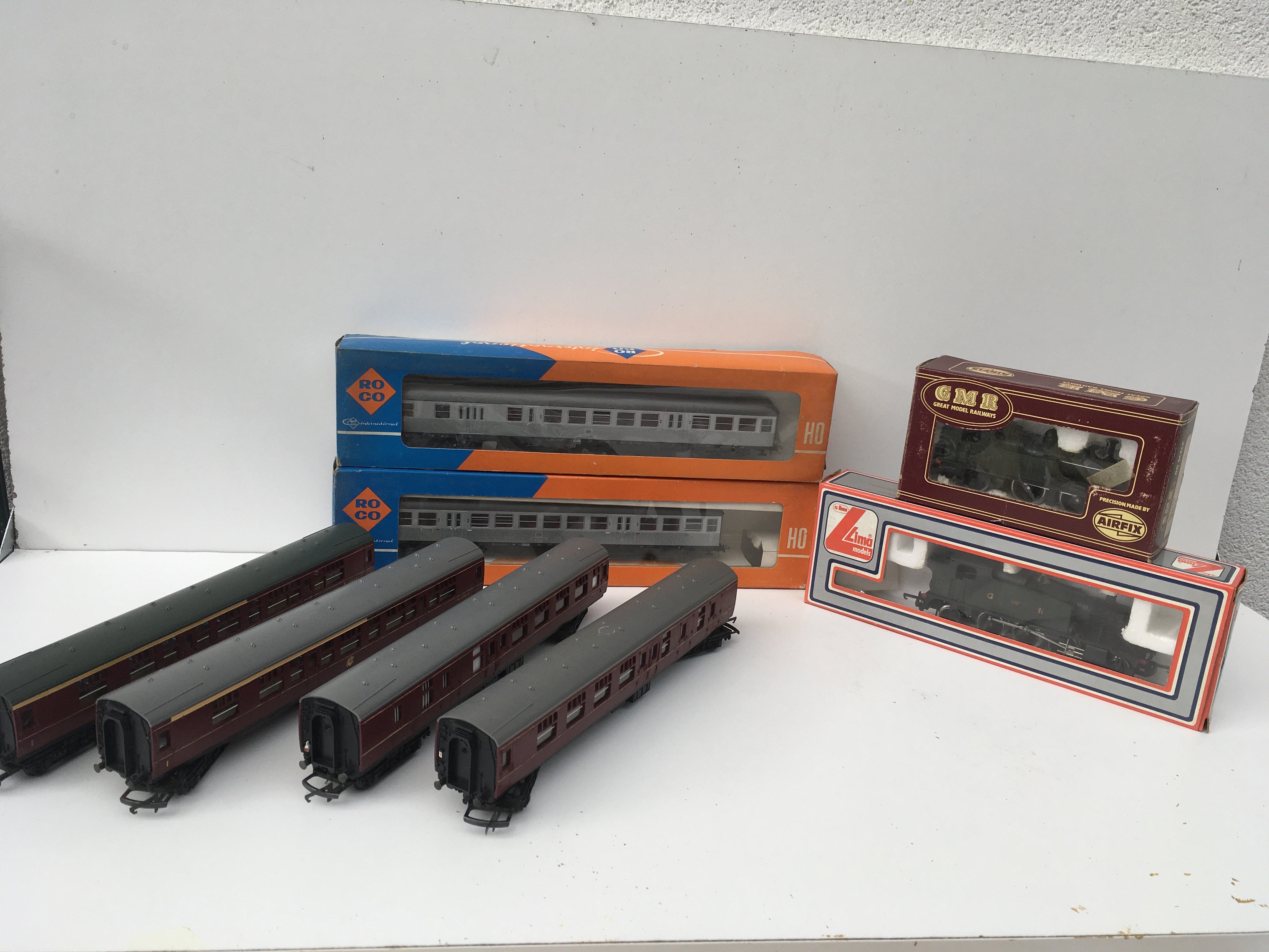 2x boxed OO gauge locomotives by Lima and GMR plus 2x boxed coaches by RoCo HO gauge plus 4 x loose coaches by Triang OO gauge. No reserve
