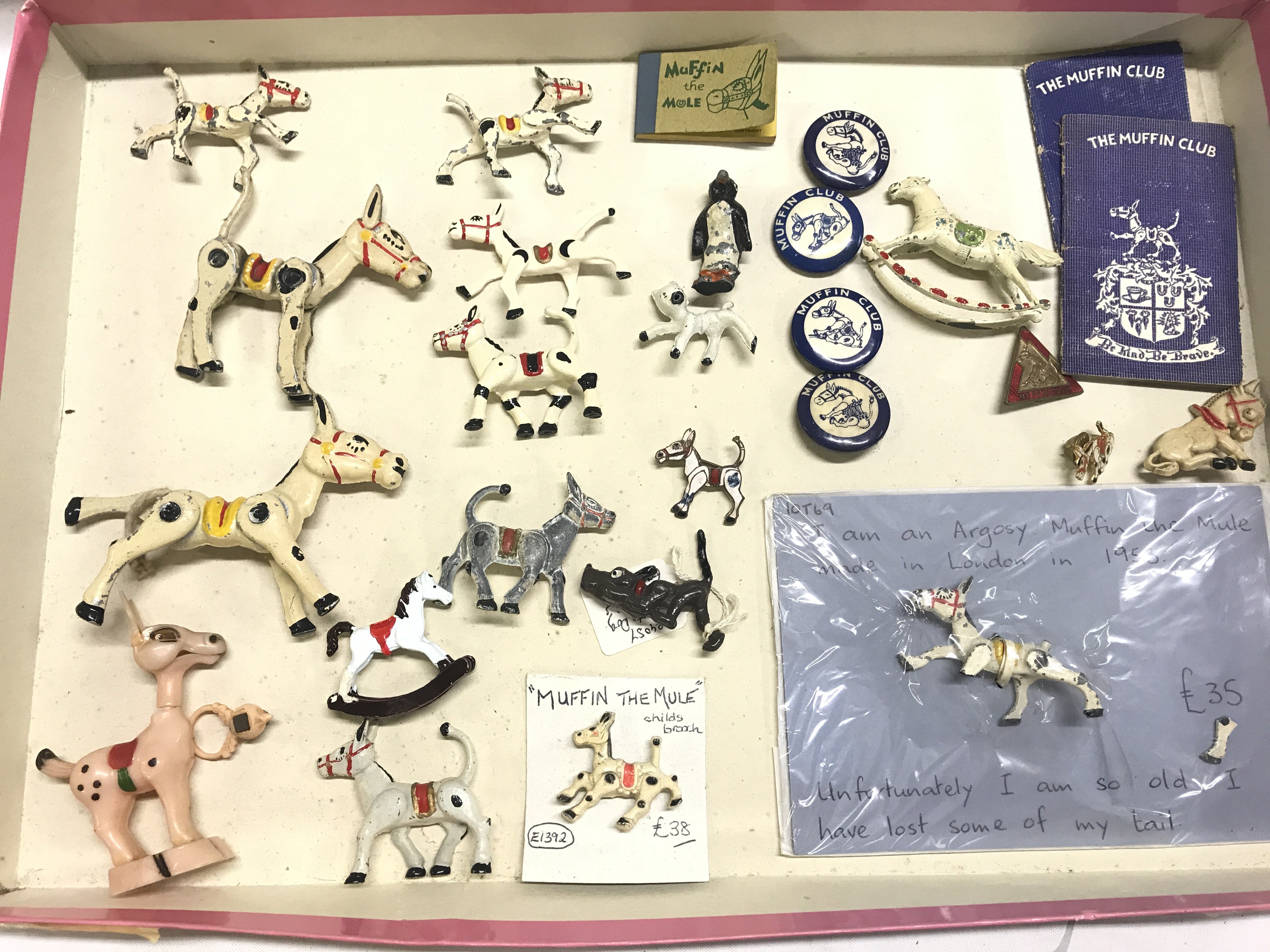 A Box Containing Muffin The Mule Diecast. Pin Badges. Etc.