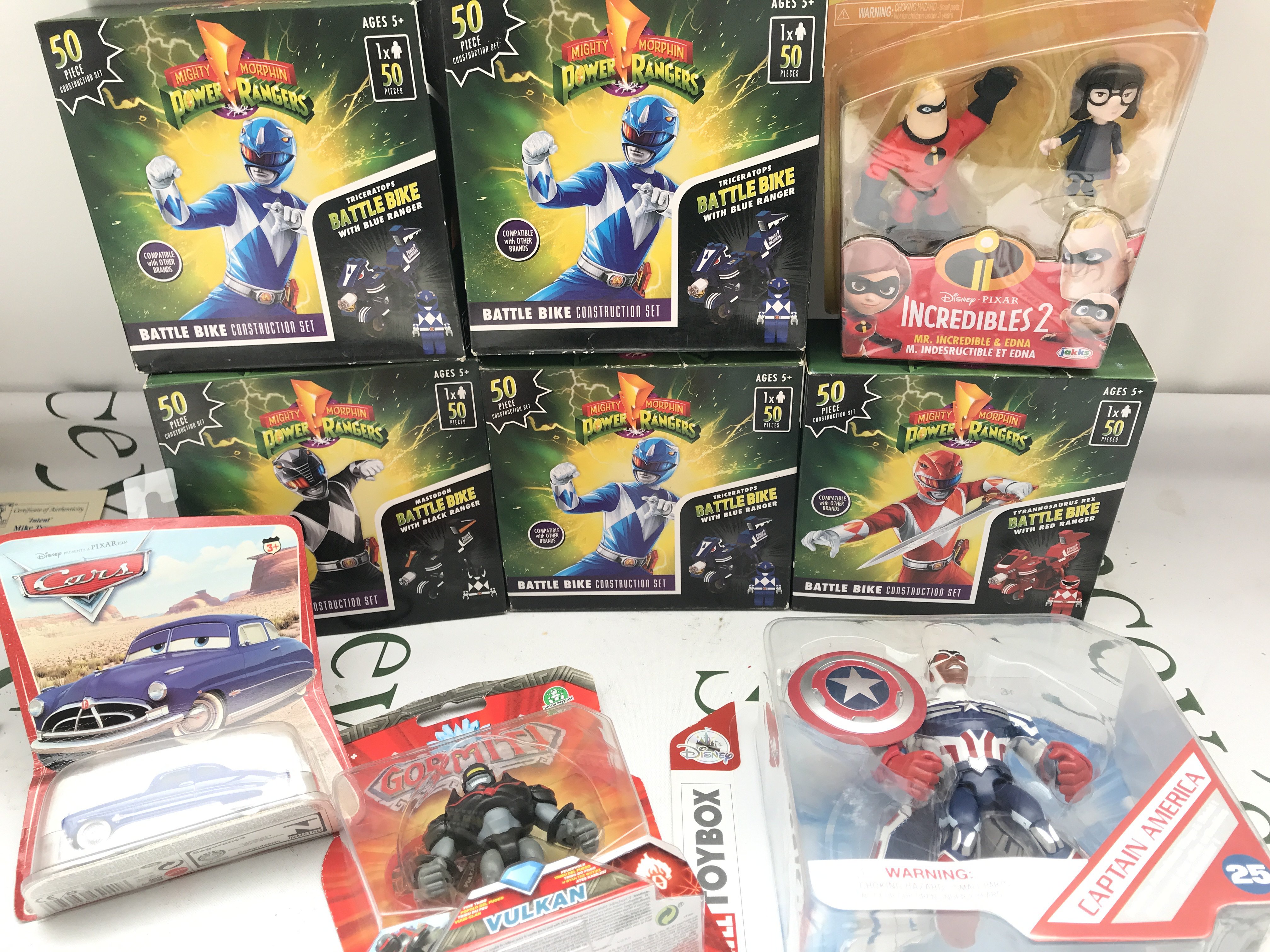 A Collection Of Boxed And a loose Toys. Including power Rangers. Masters Of The Universe. Power Rangers Sticker Books etc. No Reserve.