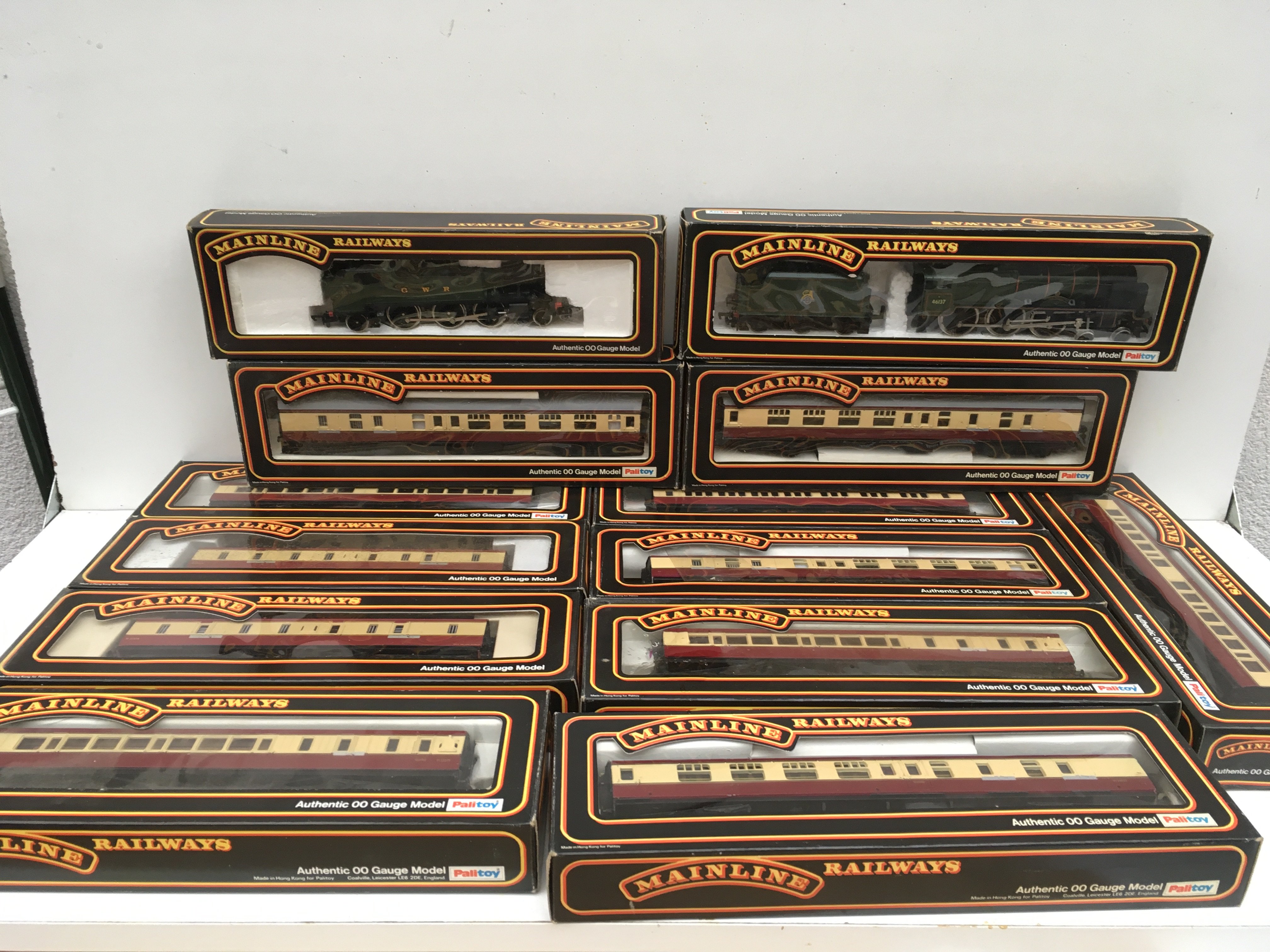A collection of boxed 00 gauge model railway pieces featuring 2x locomotives and 9 coaches. No reserve.