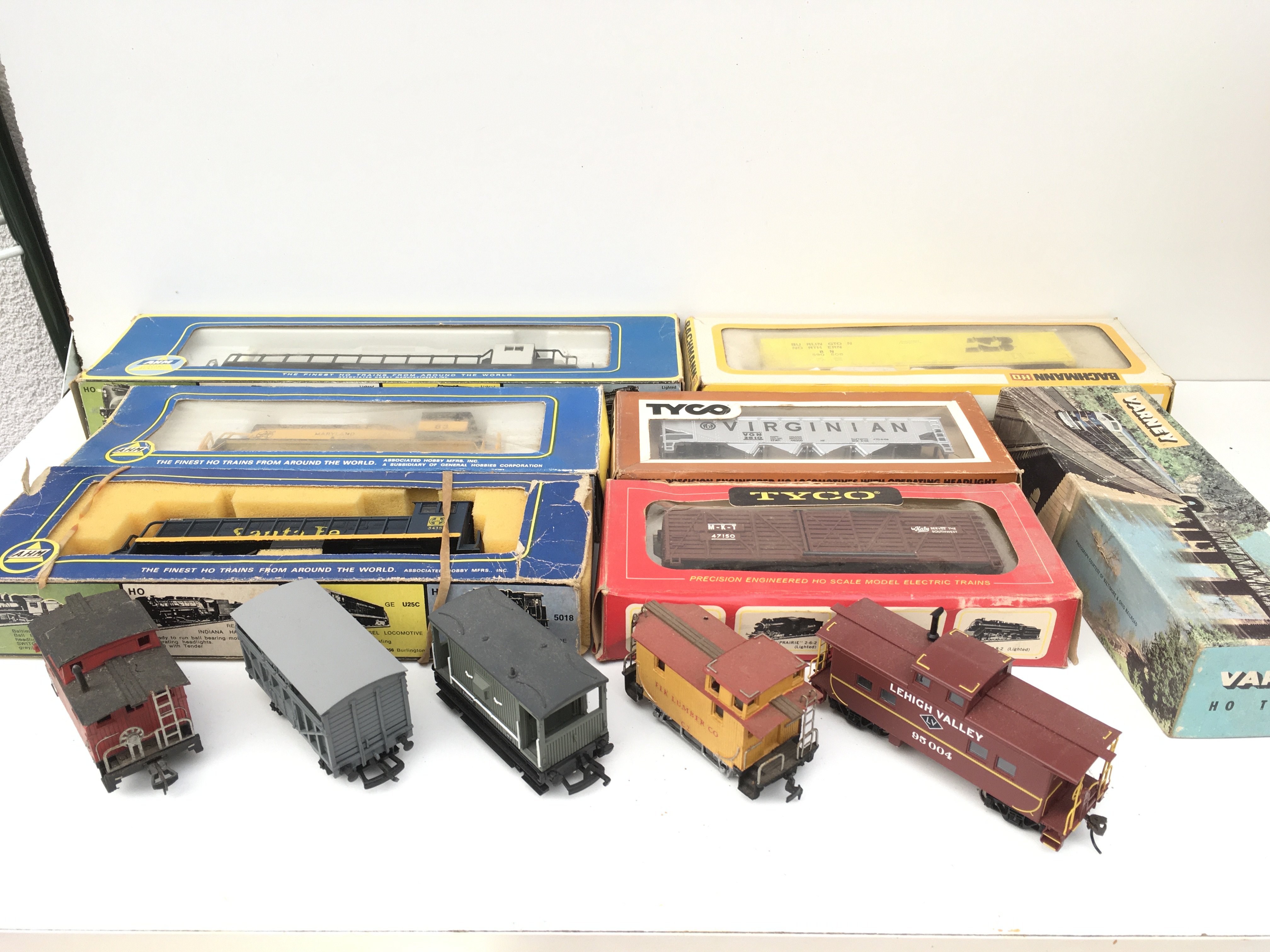 A collection 12 HO or OO gauge model railway accessories including 3x locomotives by AHM and 9 wagons by Bachmann..Tyco etc. mostly boxed. No reserve