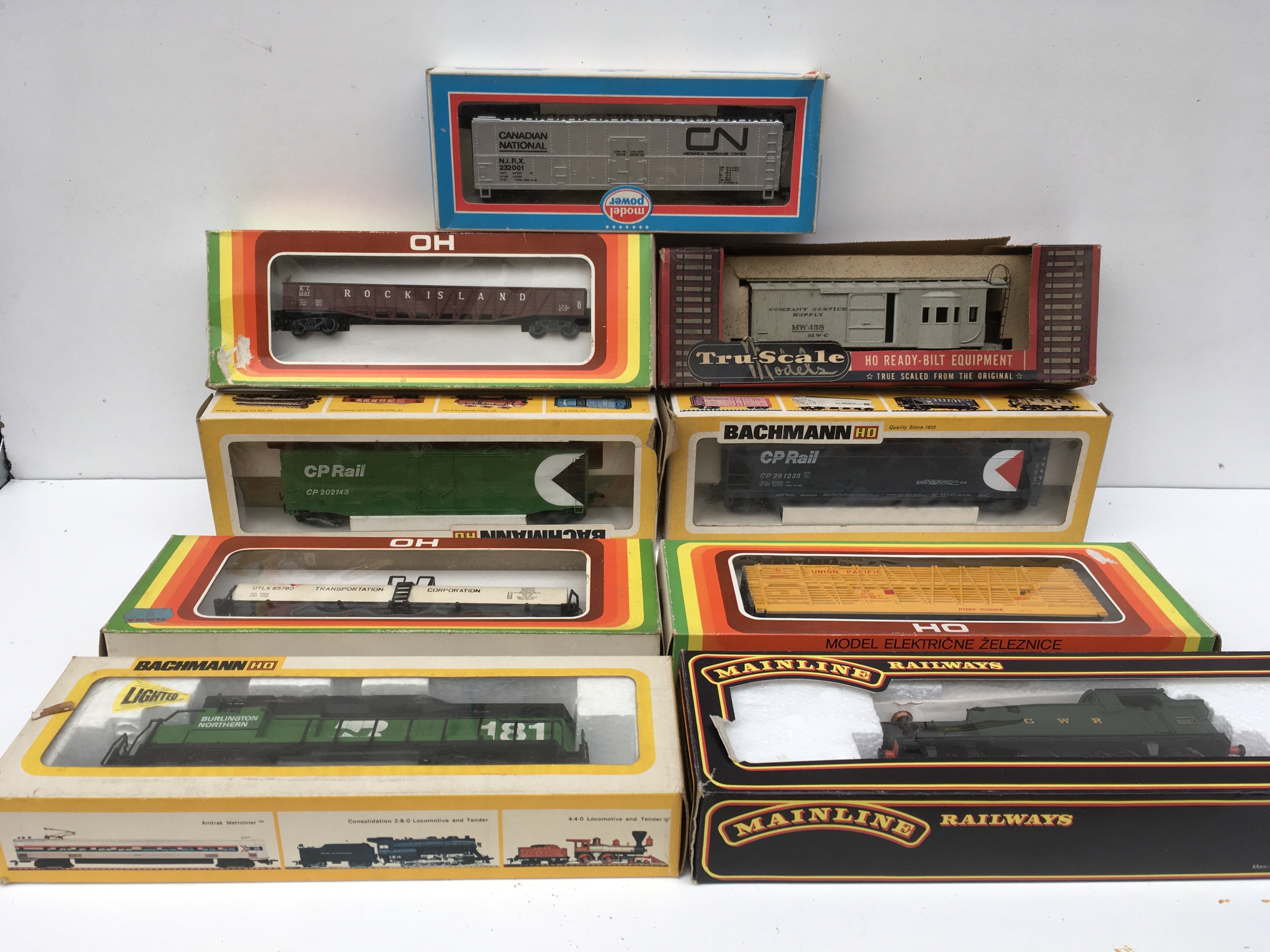 A collection of nine boxed OO and HO model railway accessories including 2 x Locomotives by Bachmann and Mainline plus 7x rolling stock wagons. No reserve