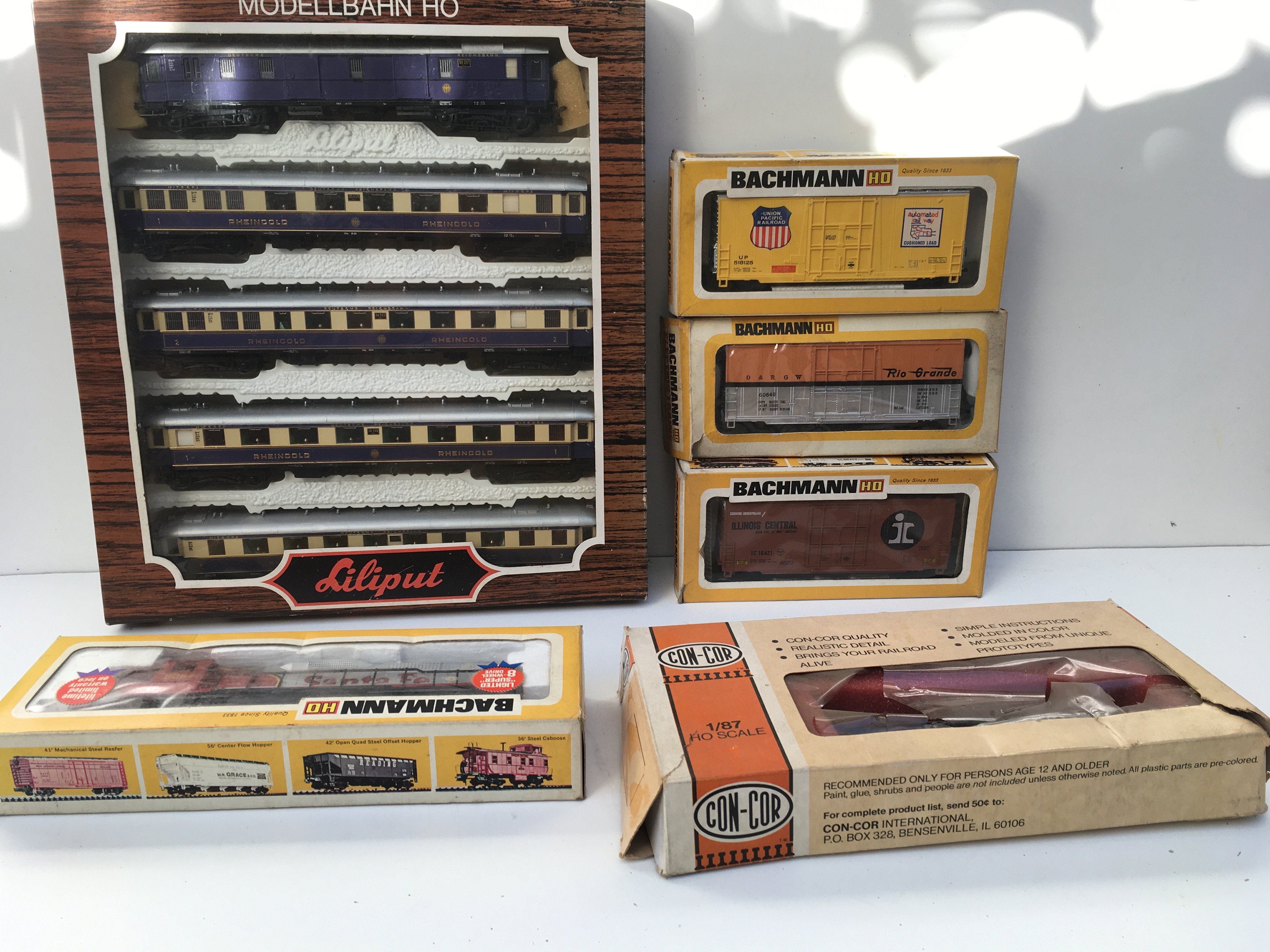 A collection of boxed HO gauge model railway items including a locomotive by Bachmann plus Part loco by ConCor. Also includes 3x Box cars by Bachmann plus a set of 5 carriages by Lilliput. No reserve.