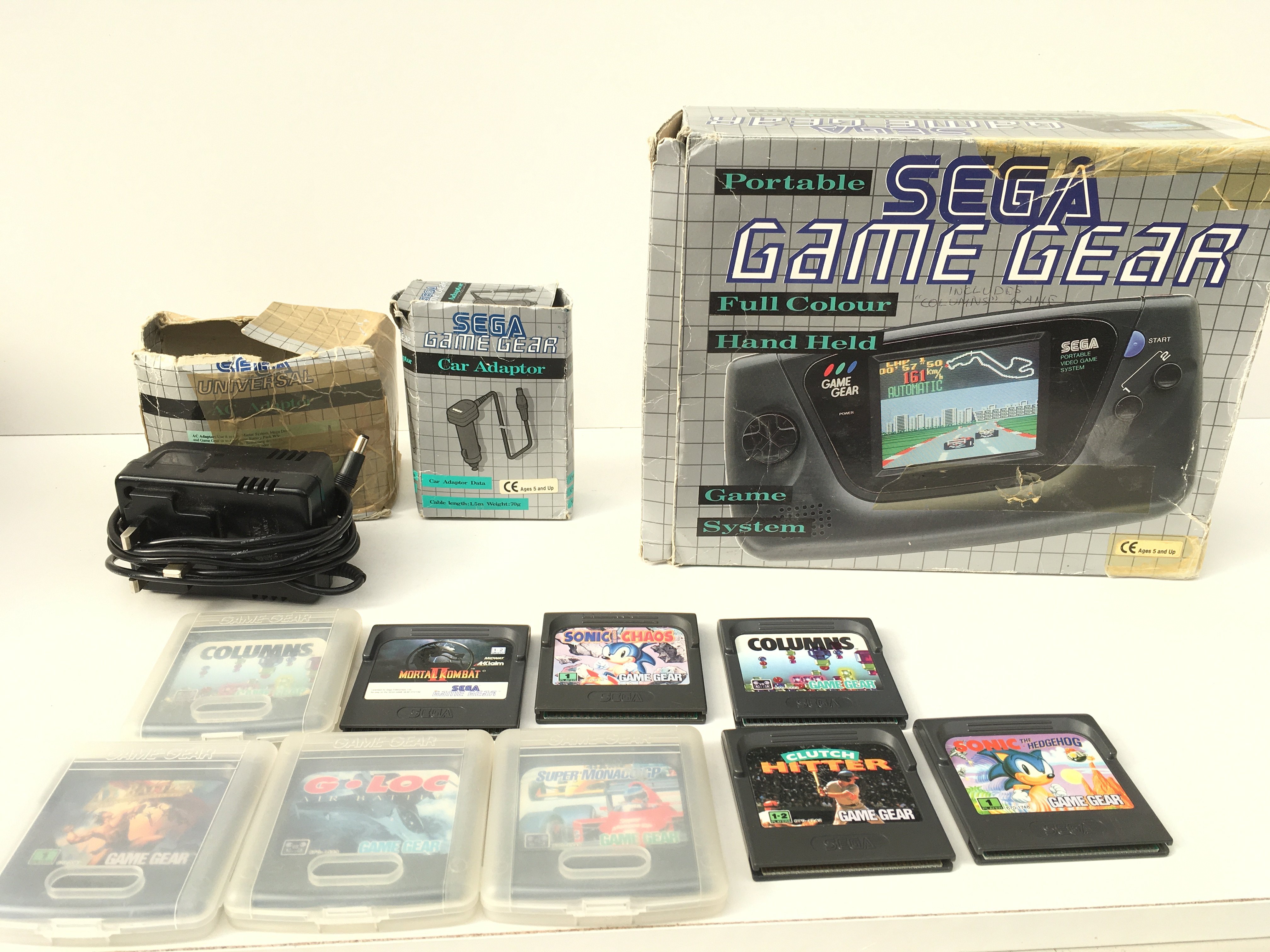 A boxed SEGA Game Gear portable game system. Includes manual. AC power supply. Car adaptor and 9 game cartridges. No reserve