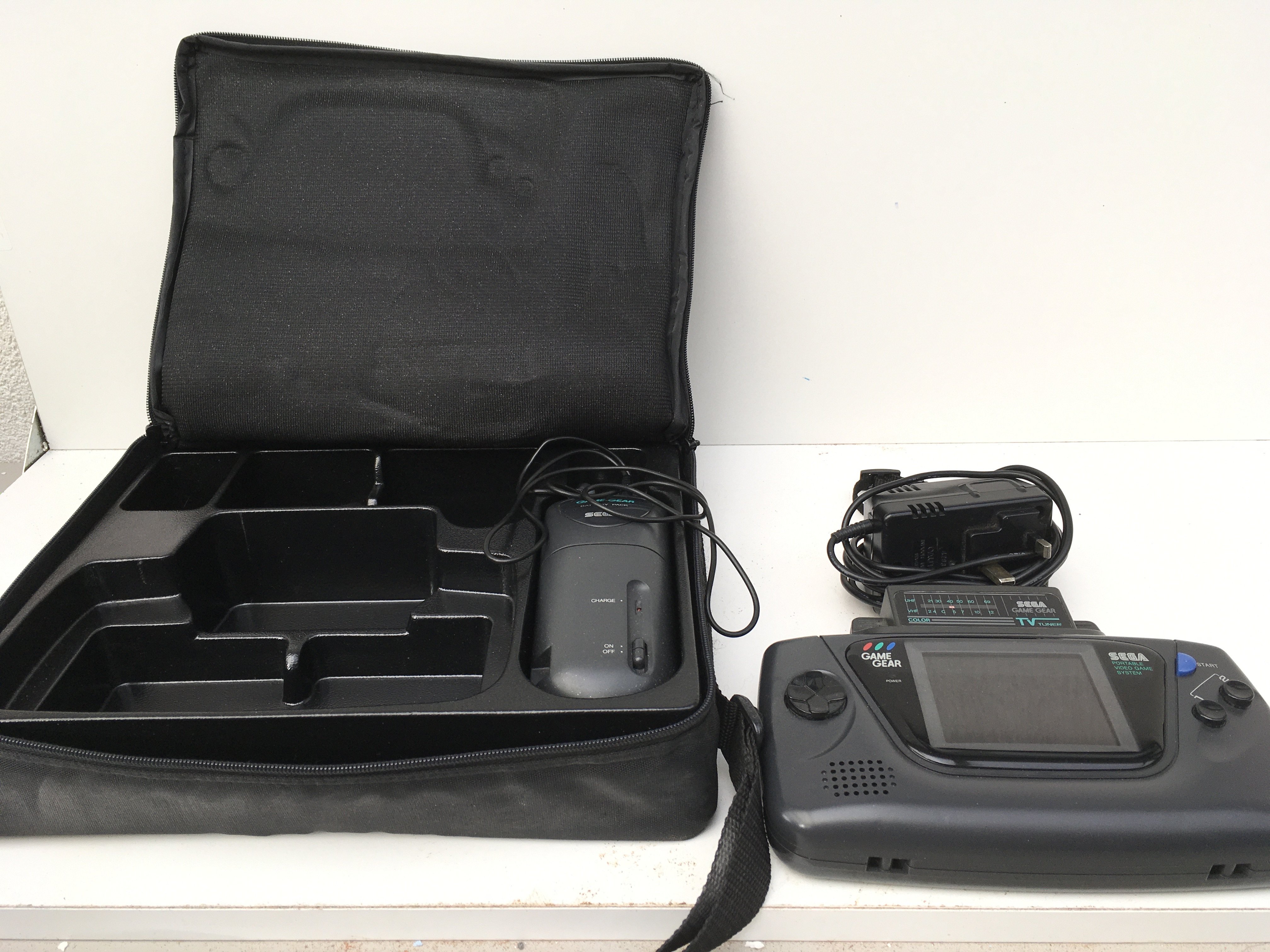 A Sega Game Gear includes hold-all..batterpack..AC power supply..TV tuner and hand stap. No reserve