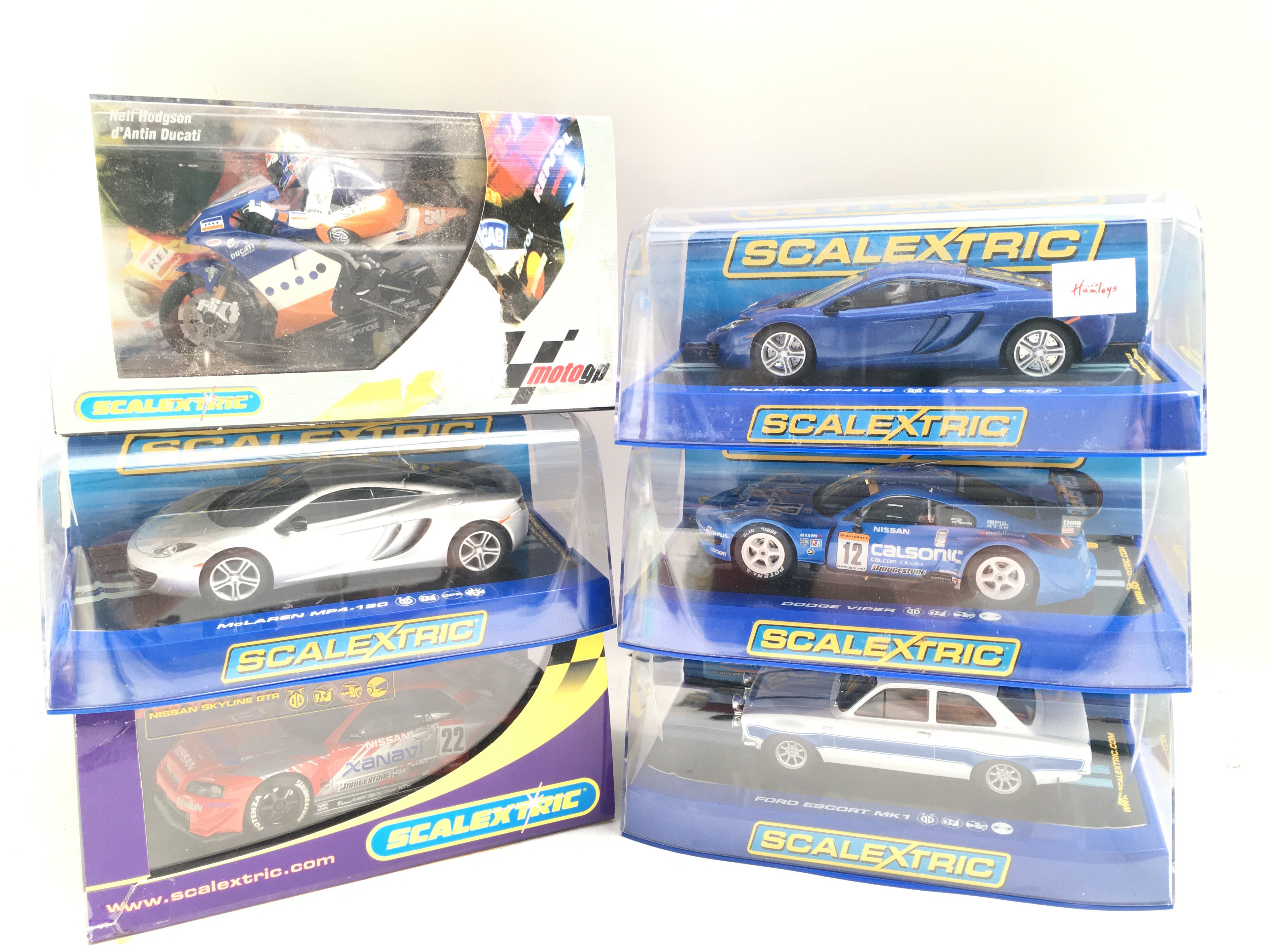 6 Boxed Scalextric Vehicles. Including 2 McLaren MP4-12c. A Dodge Viper. A Ford Escort MK 1. A Nissan Skyline And a Moto GP Neil Hodgson Bike.
