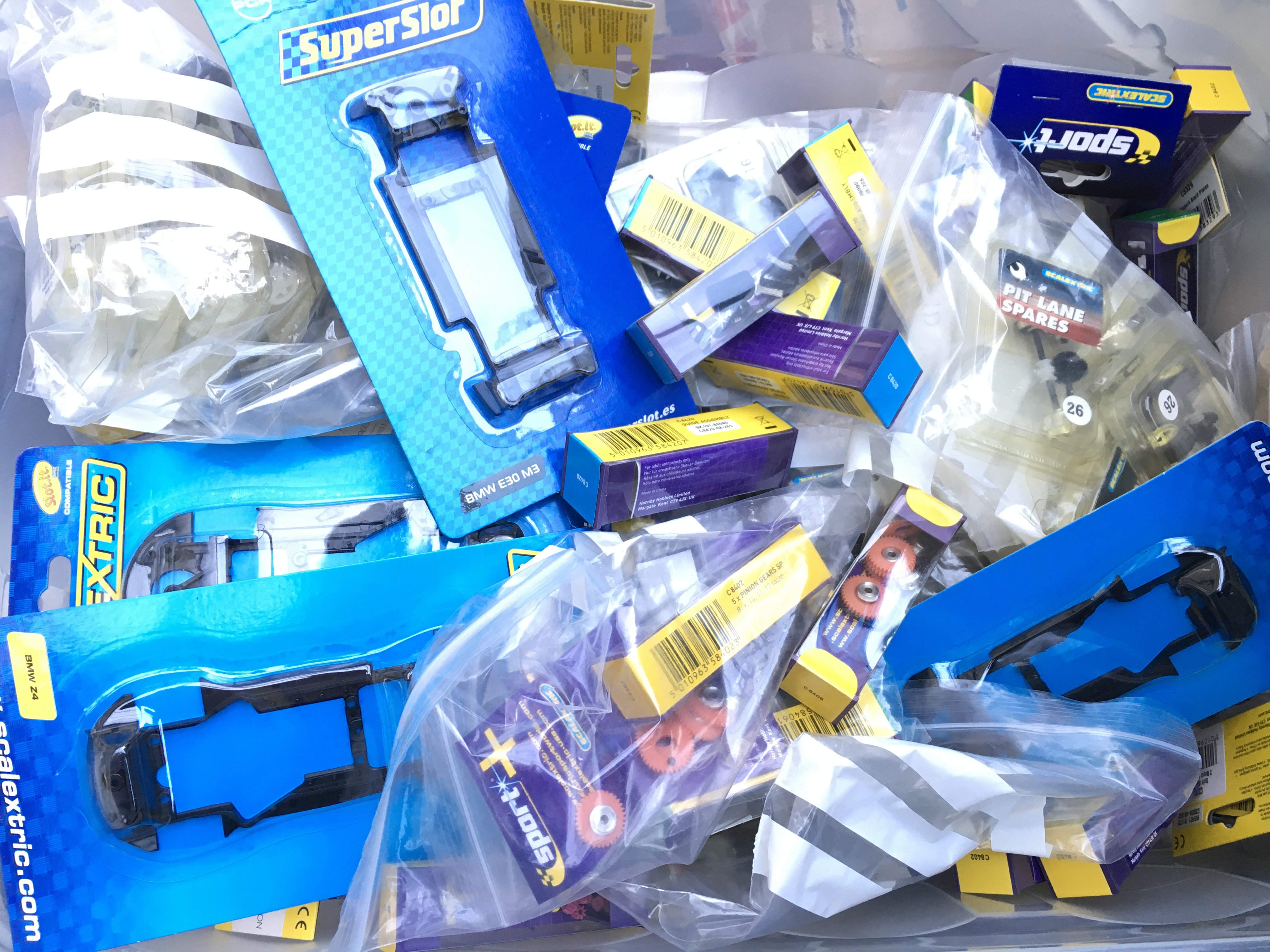 A Box Containing a Collection of New Scalextric Spare Parts.