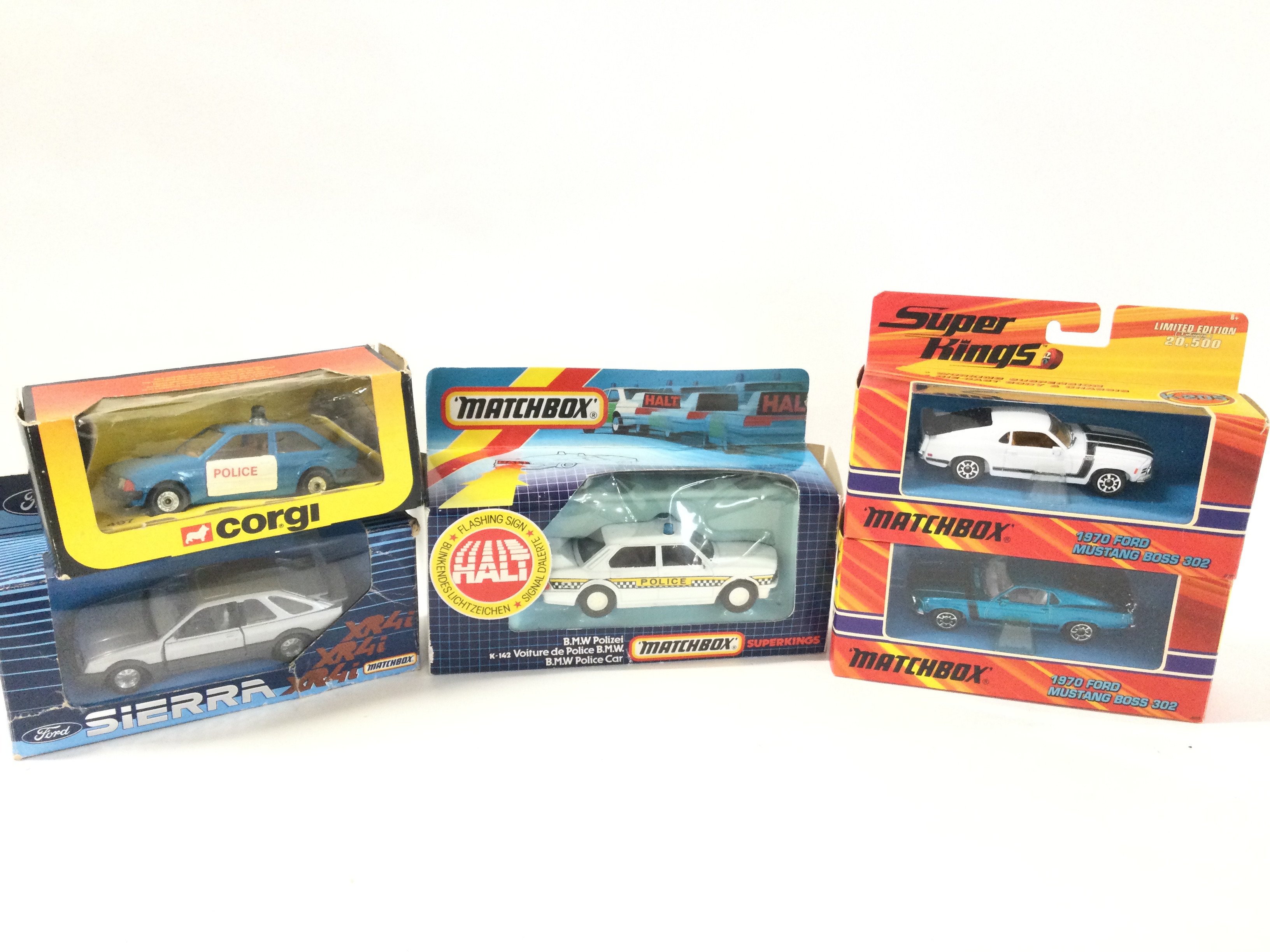 5 Boxed Diecast Cars Including A Matchbox Sierra. A Corgi Ford Escort. A Matchbox BMW And 2 Repro Mastangs.