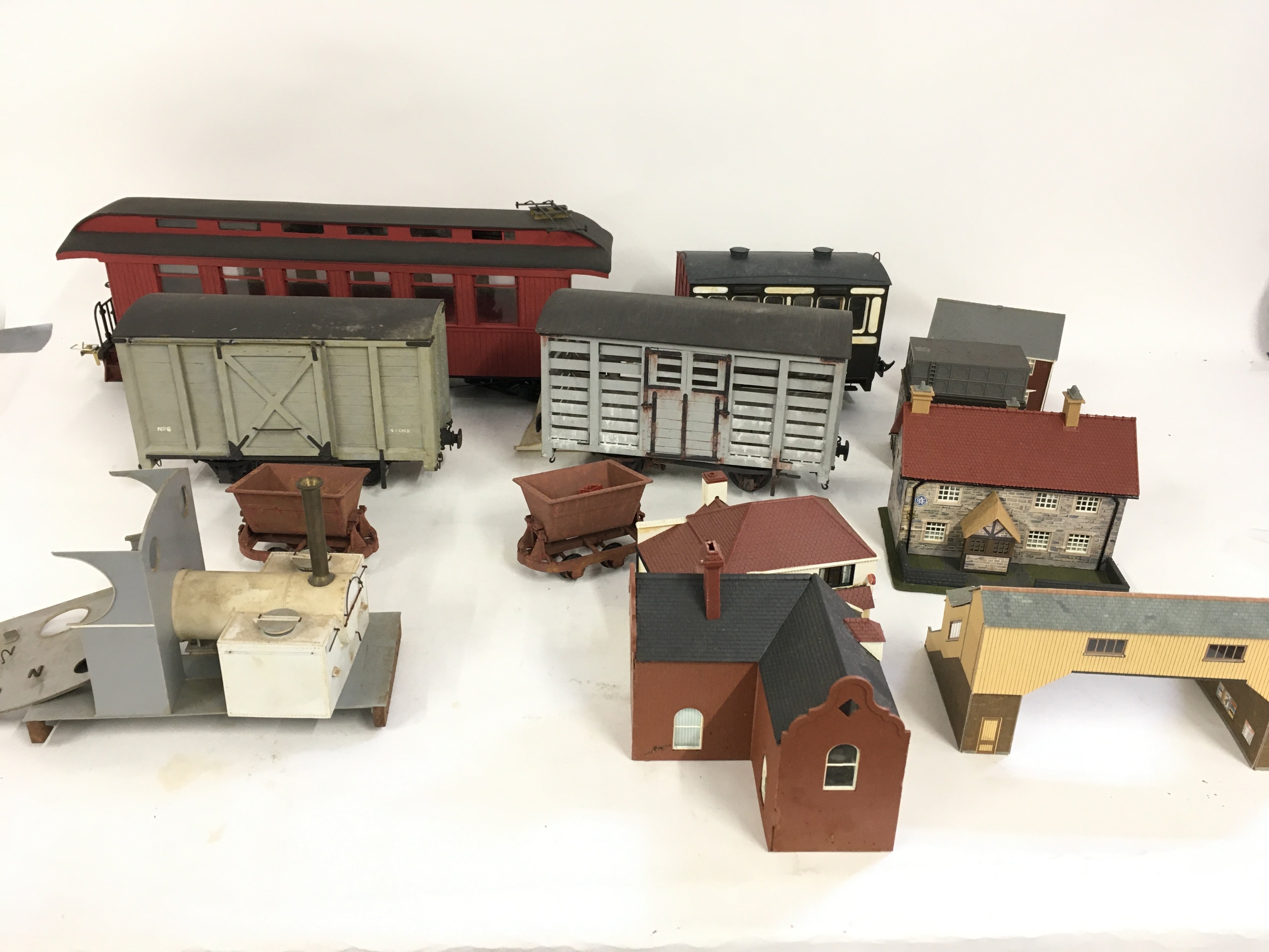 A collection of O gauge railway wagons and coaches plus a number of assembled and painted plastic buildings for scenery. No reserve.