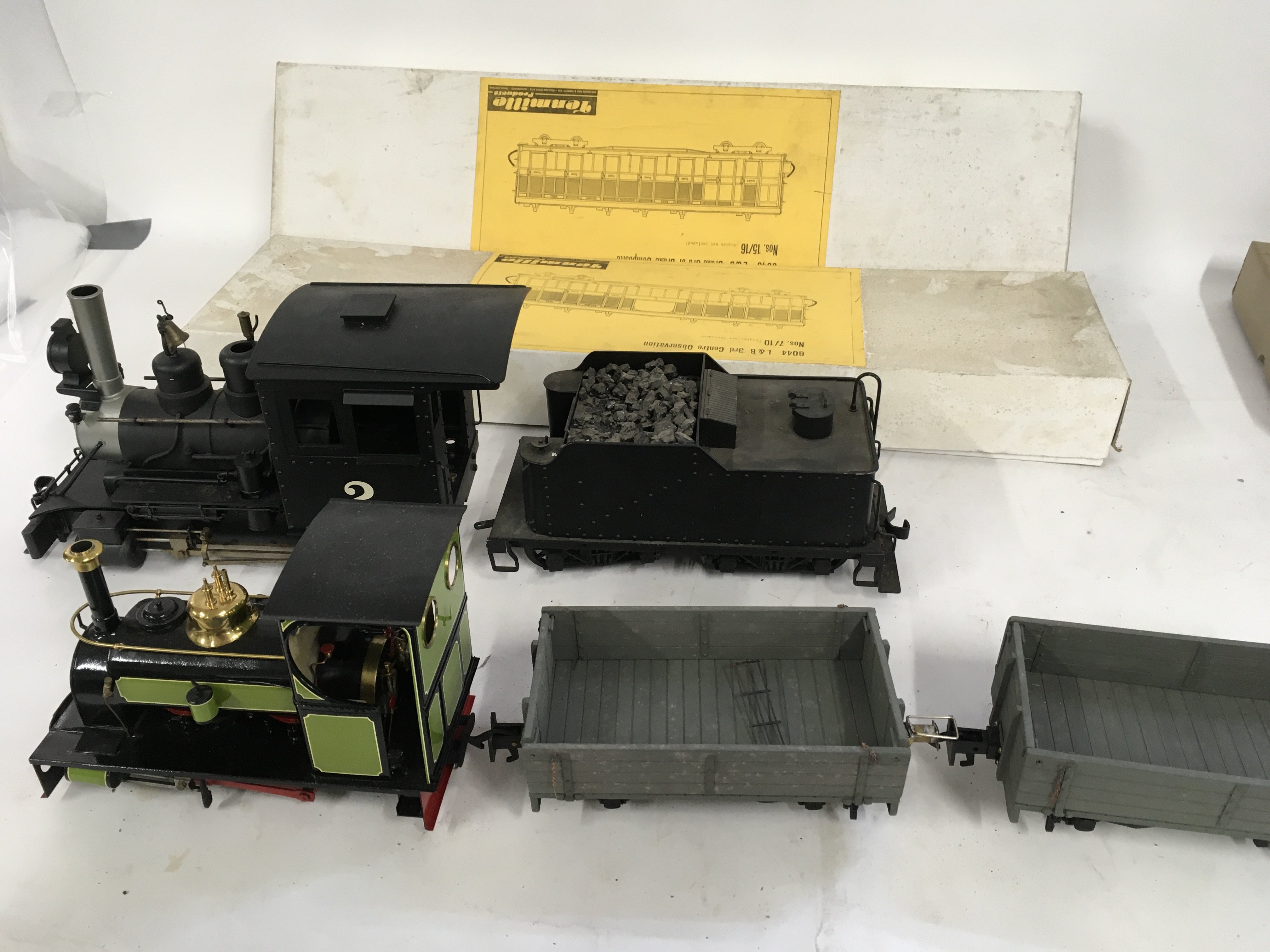 A pair of 0 gauge steam locomotives incomplete plus tender and wagons. Includes 2 boxed model kits by tenmille without bogies. No reserve