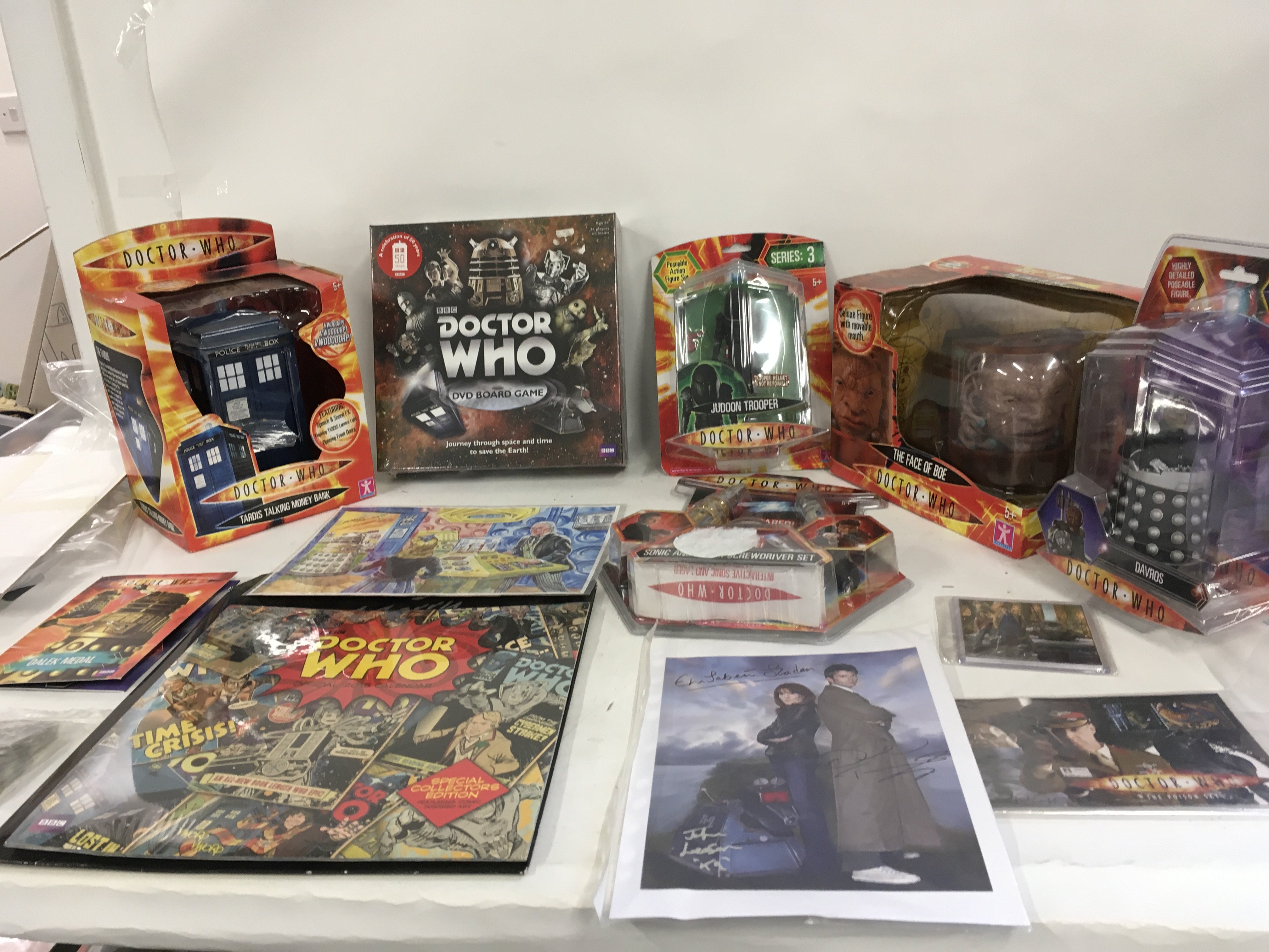 A collection of unopened boxed Dr Who Toys plus other items comprising Tardis Talking Moneybank. The Face of Boe with moveable mouth. Jadson Trooper. Davros. Sonic and Laser Screwdriver set..Dalek Medal..various Doctor stickers. Tardis Operators licence. Collectors edition 2015 calendar. First dat issue stamps The Poison Sky. Signed print featuring Dr who. Sarah Jane and K9. Art print featuring Doctor. Jane and Dalek in Tardis. Signed by Walt Howarth. COA