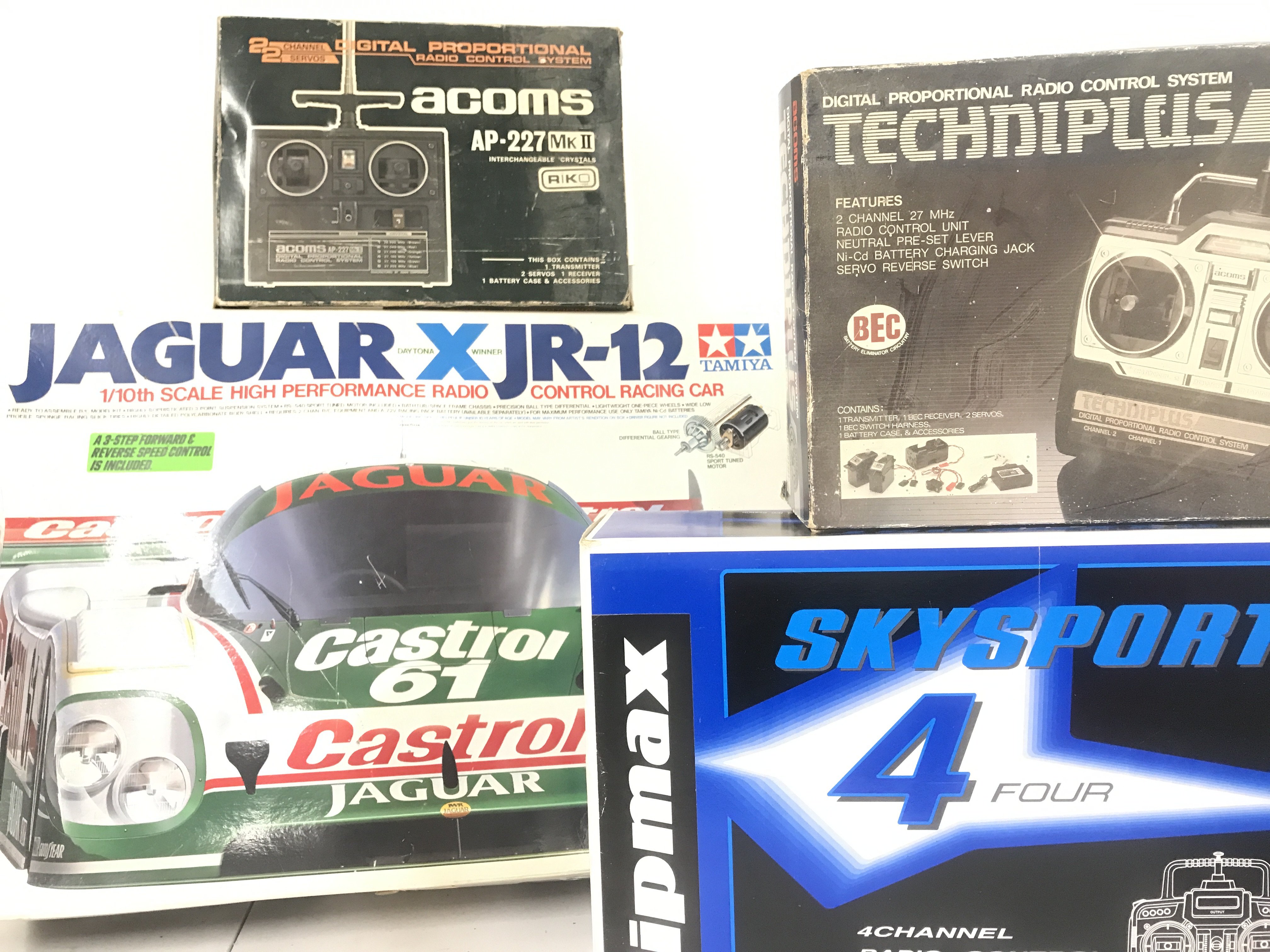 A Boxed Tamiya 1/10th Scale Radio Controlled Jaguar X JR-12 Racing Car Model Kit With 3 Boxed Controllers.(4).