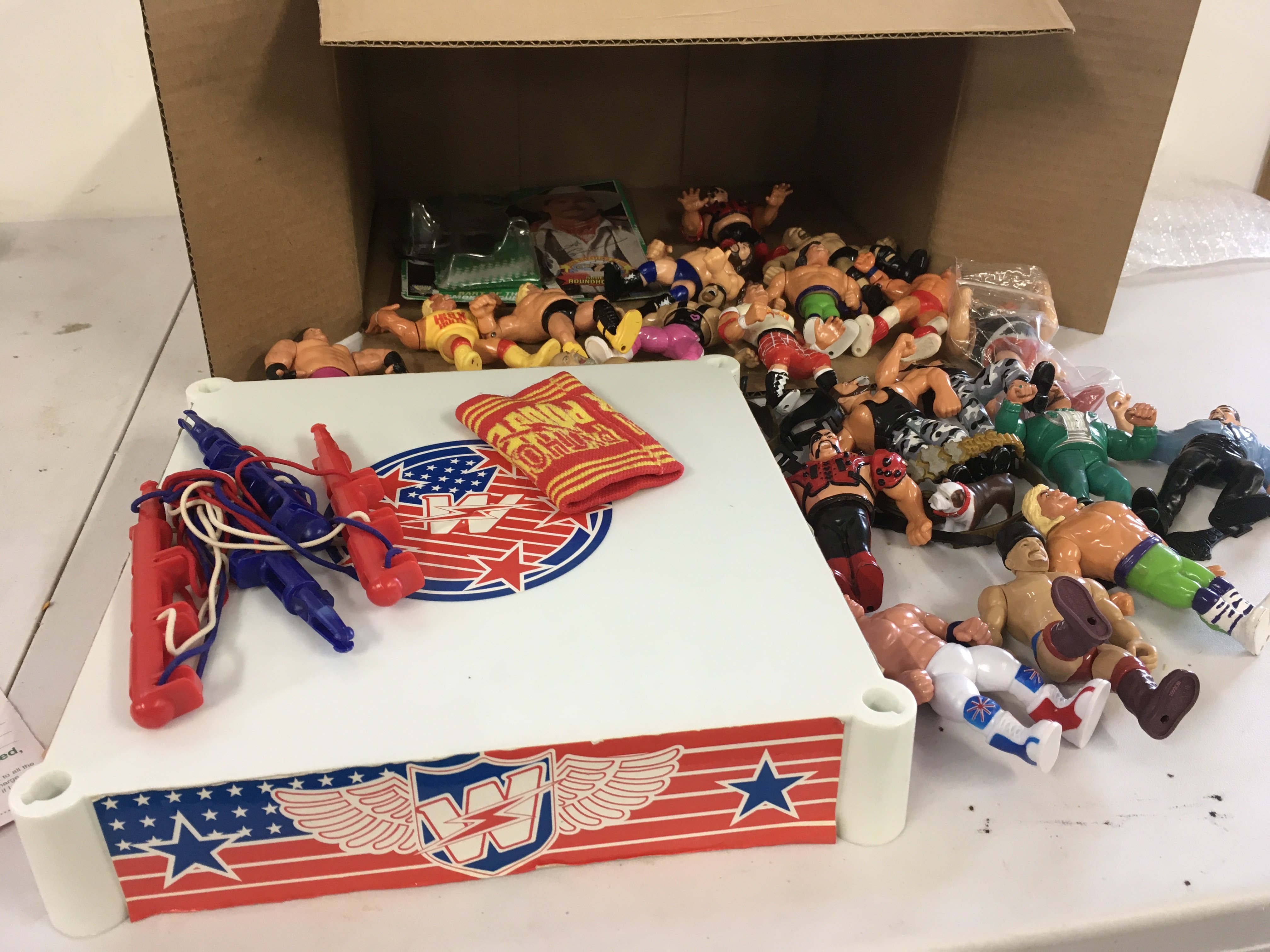 A collection of vintage and retro WWF Hasbro figures.  Includes wrestling ring and numerous belts.