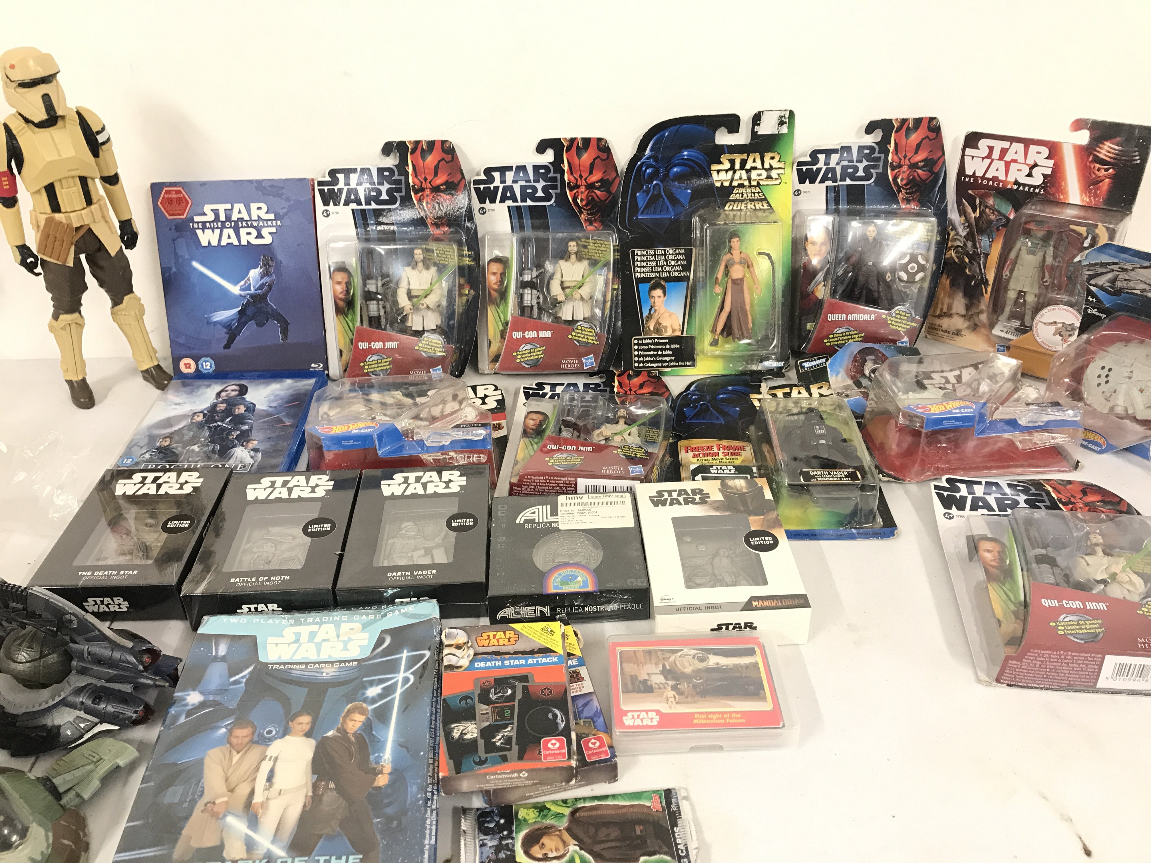 A Box Containing Various Carded Star Wars Figures. Collectors Imgots. DVDs. And Books. No Reserve.