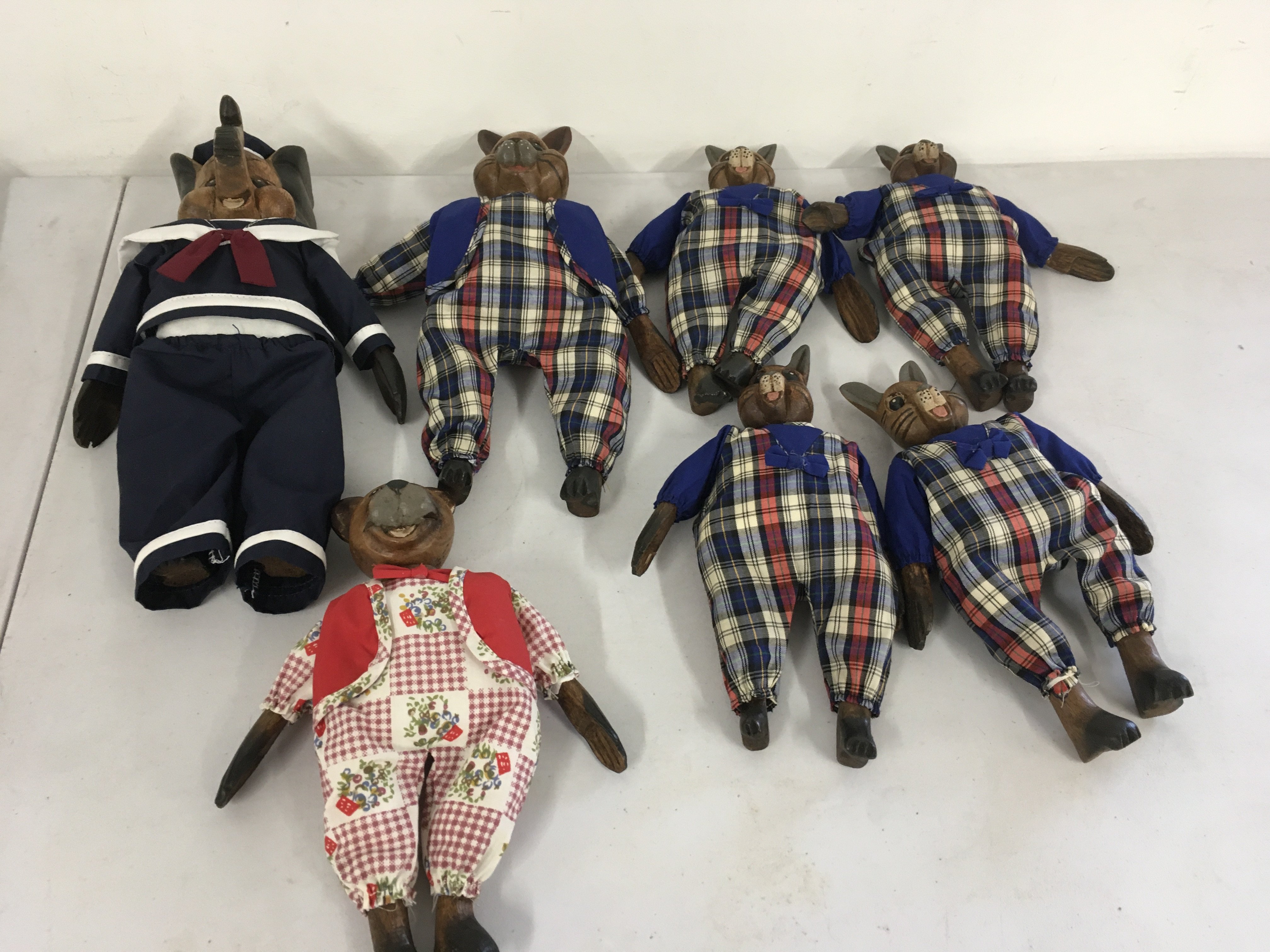 A collection of 7 toy animal figures  with carved wooden heads..hands and feet with stuffed bodies all dressed.  No reserve 