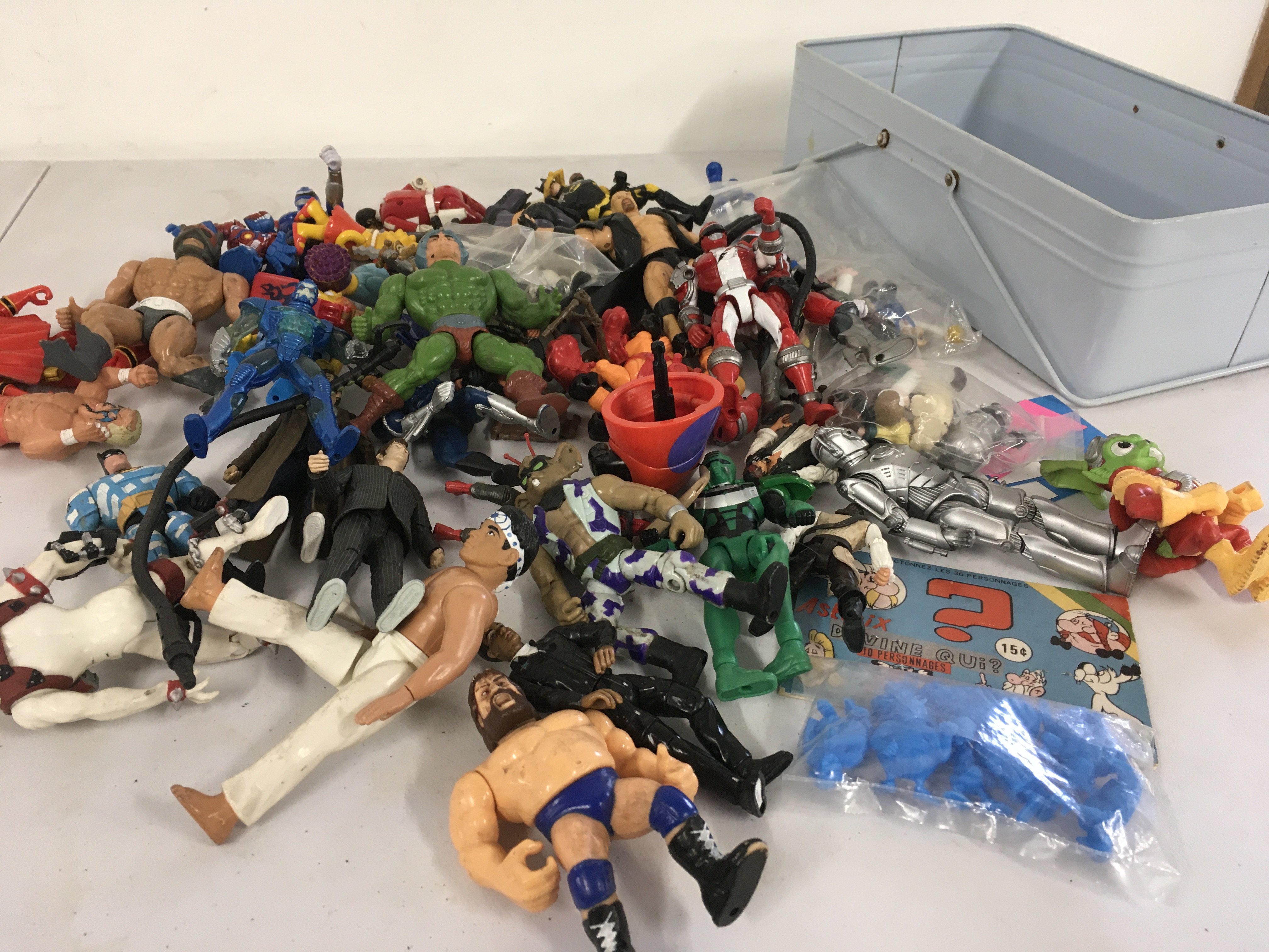 A box containing a mixture of action figures by various manufacturers and characters including Batman..Dr Who..Karate kid..HeMan..WWF..Simpson etc.  no reserve 