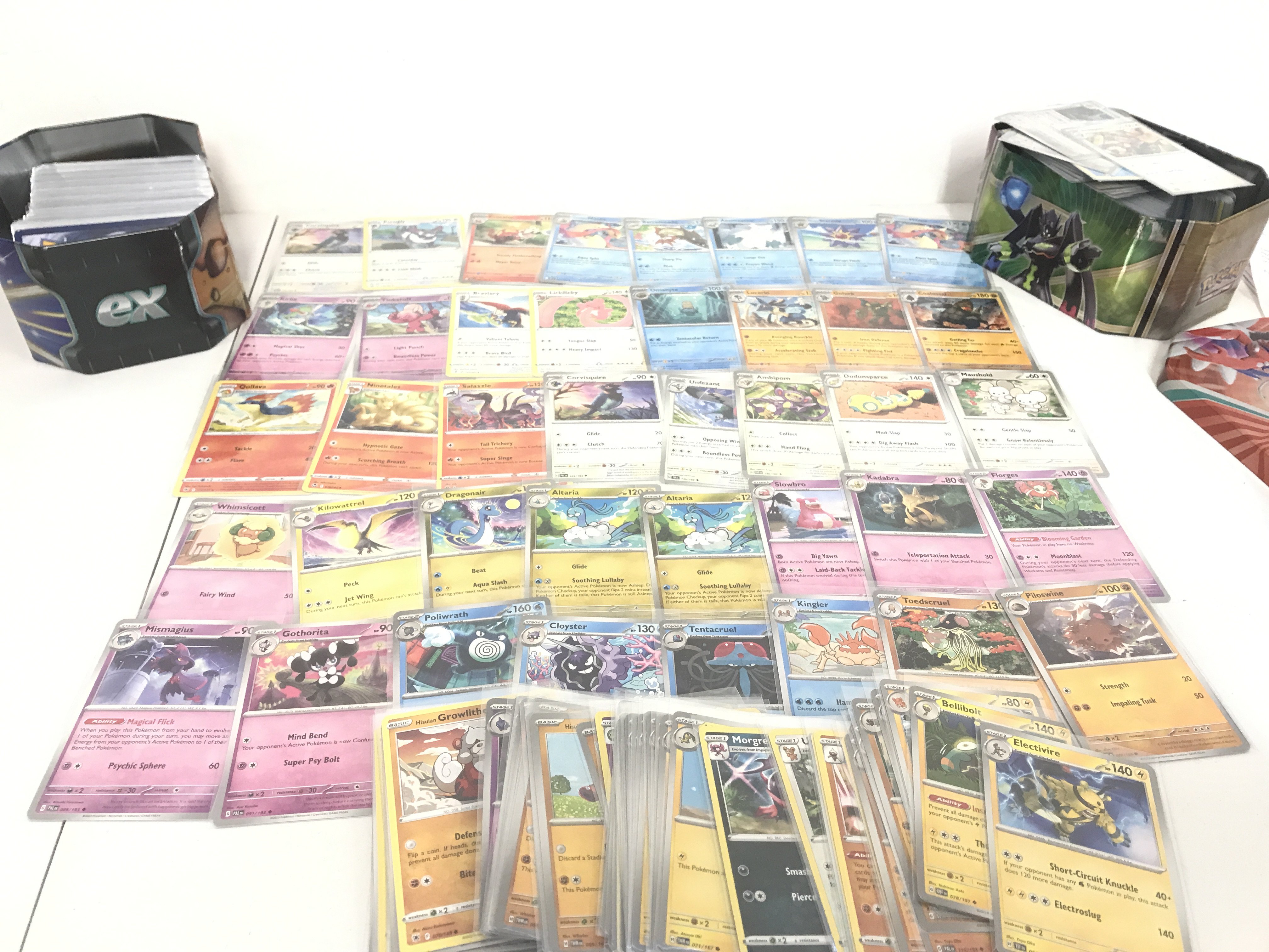 A Collection Of Pokemon Cards in Two Tins. Approximately 500 In Protective Sleeves. No Reserve. 