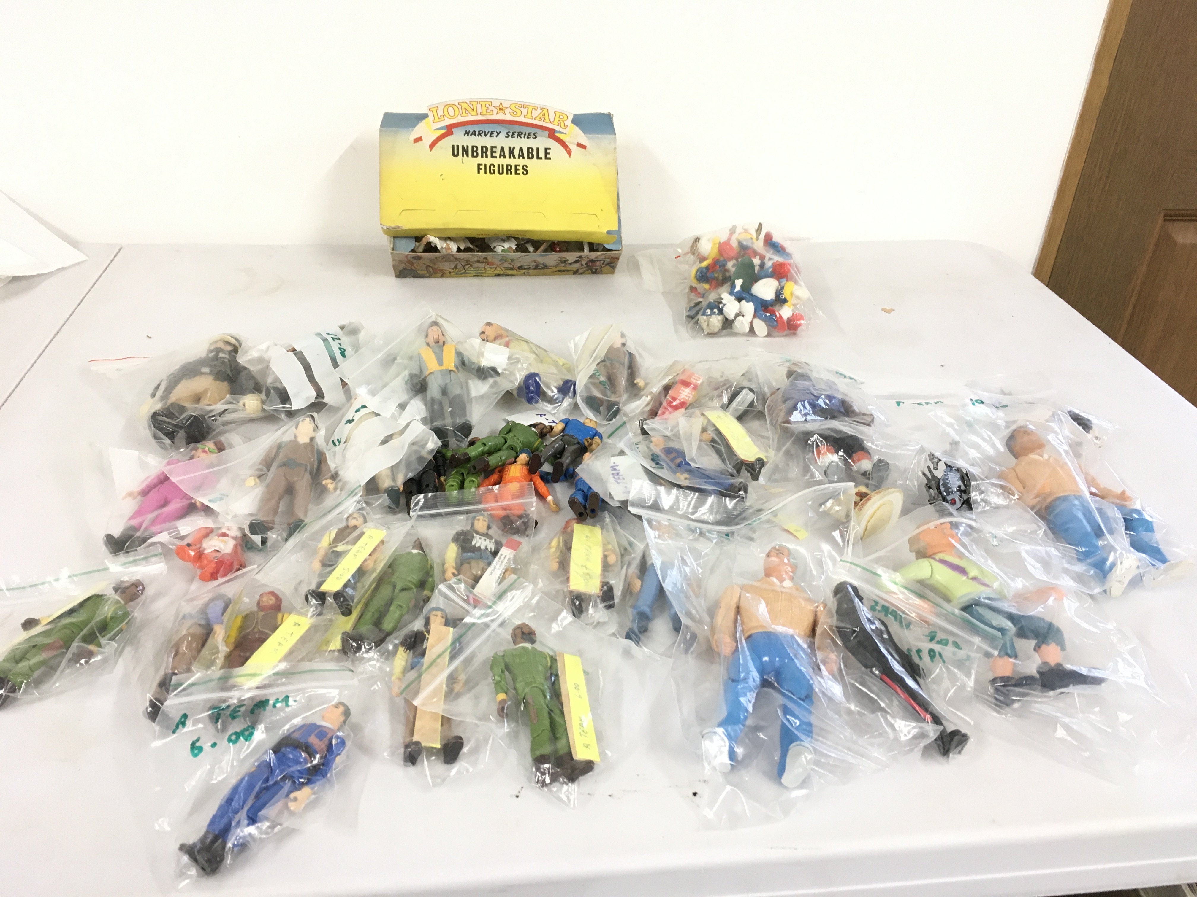 A collection of action figures predominantly featuring The A Team and Ghostbusters.  Also includes retailers box of Lone Star unbreakable figures featuring Scaracens.   Plus a small bag of Smurfs. No reserve