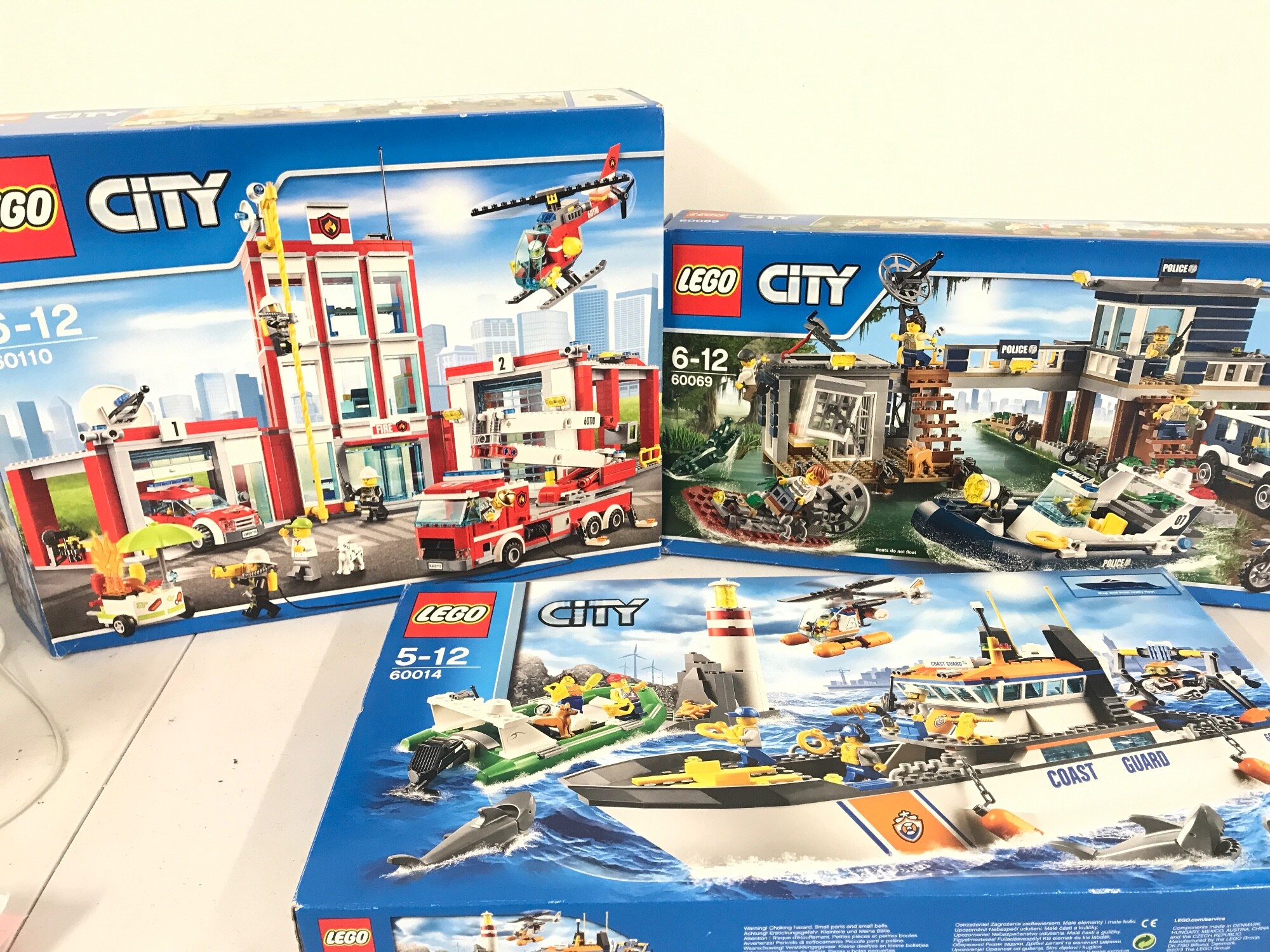 Three opened Lego city sets number 60110, 60069 and 60014.