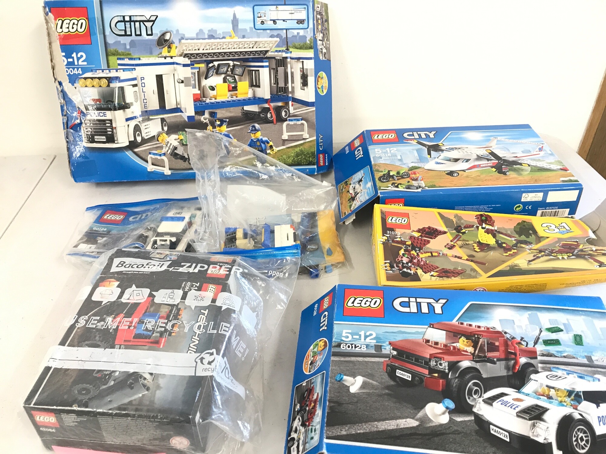 A collection of opened lego sets including city Lego.