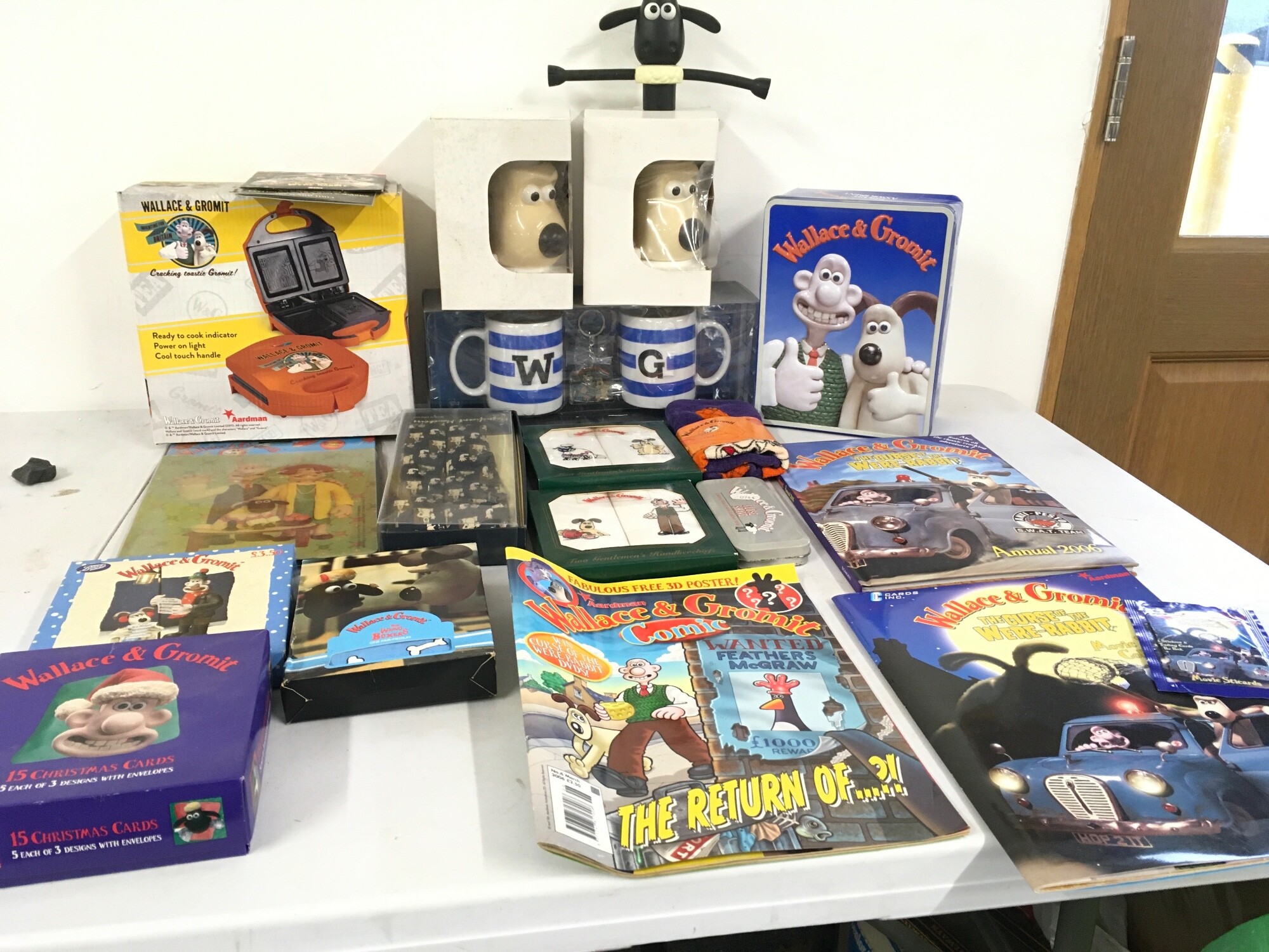 A varied collection of Wallace and Gromit merchandise, including Toastie maker, Mugs, handkerchiefs , braces , tin of biscuits ( not for eating) etc.  no reserve